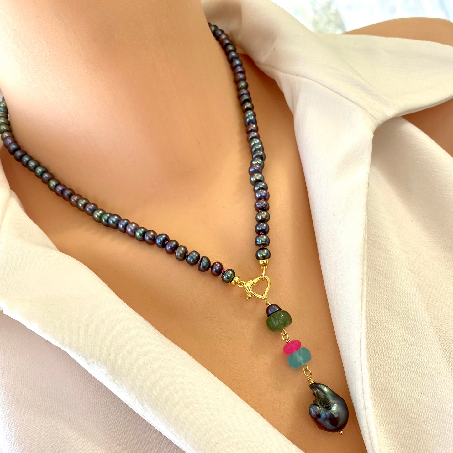 Black pearl necklace with chalcedony and chrysoprase worn on model with heart clasp pendant