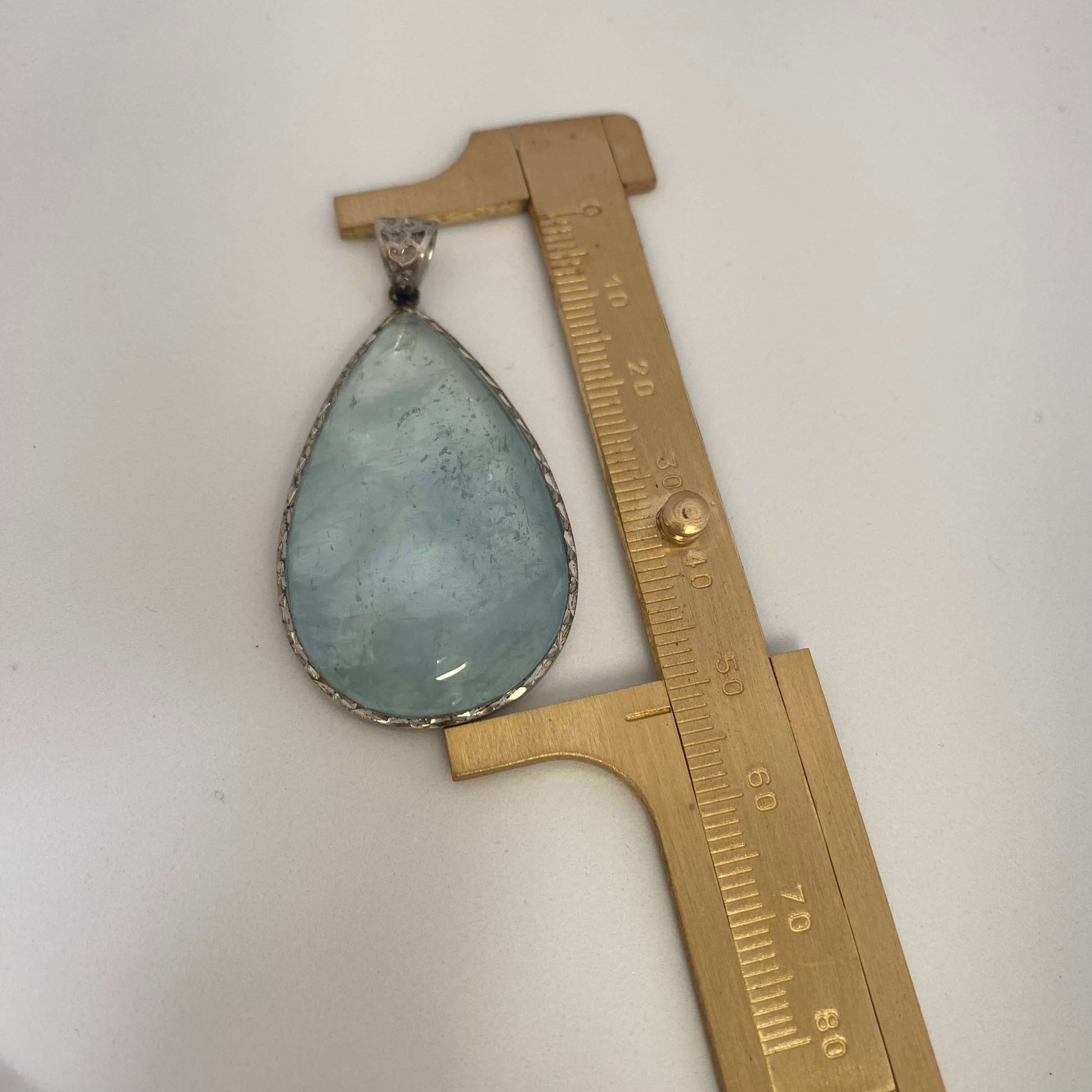 Labradorite aquamarine pendant necklace aquamarine gemstone pendant measured against ruler — size reference for handcrafted jewelry by Loulia Pearl Jewelry