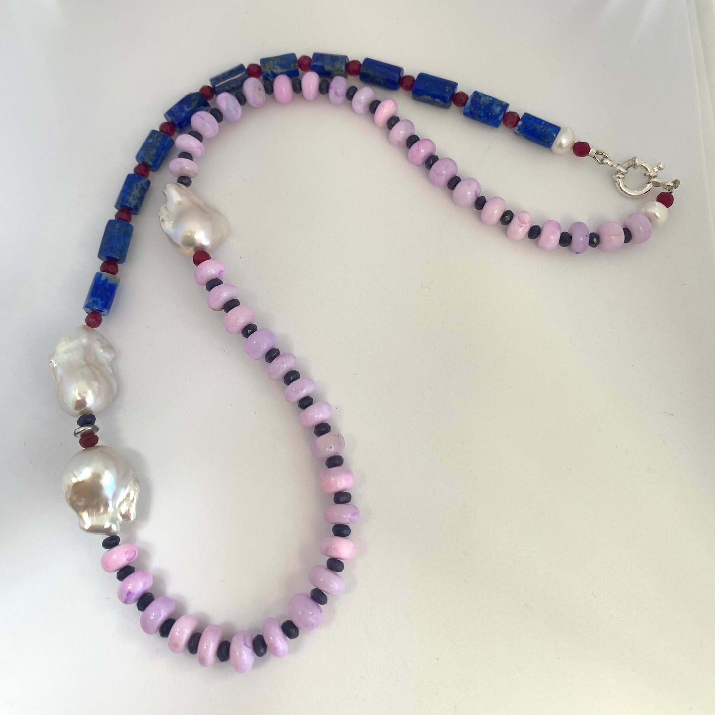 Close-up of lapis lazuli opal agate pearl necklace on white background — colorful gemstone and baroque pearl necklace handcrafted in Canada