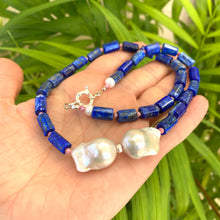 Load image into Gallery viewer, Lapis Lazuli Pink Rhodonite Baroque Pearl Necklace held in hand against green leaves — handcrafted gemstone and pearl jewelry by Loulia Pearl Jewelry
