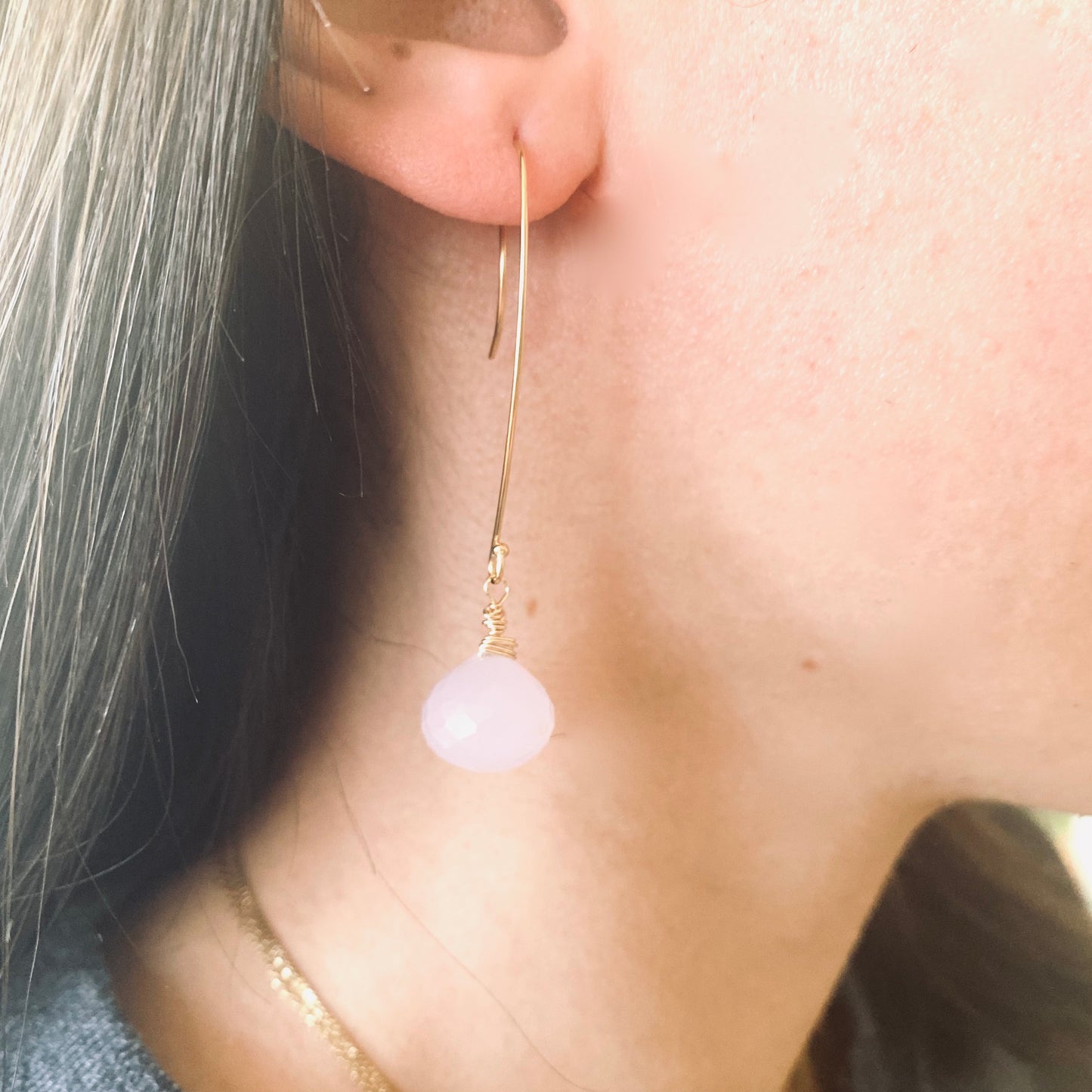Rose quartz threader earrings with onion briolettes showcased on a model's ear, highlighting their delicate design.