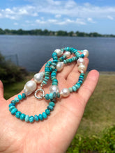 Load image into Gallery viewer, Arizona turquoise pearl necklace shown in hand beside a lake, featuring turquoise rondelle beads and large pearls.
