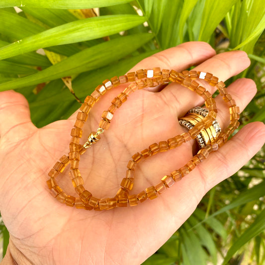 Hessonite garnet necklace displayed on a hand, showcasing warm golden-yellow cube stones with a magnetic clasp.