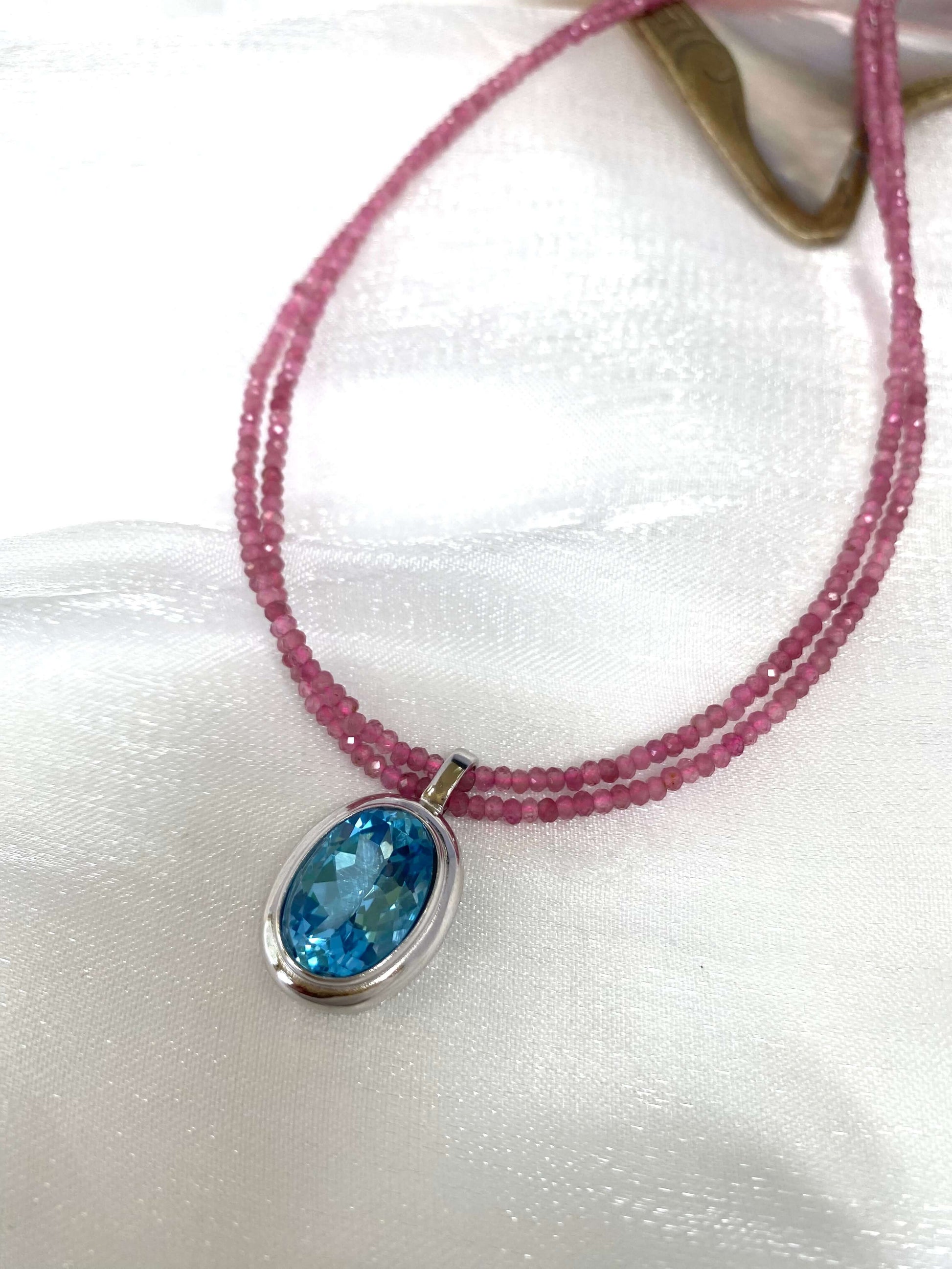 Pink Tourmaline Blue Topaz Pendant | Double Strand Design by Loulia Pearl Jewelry on elegant fabric.
