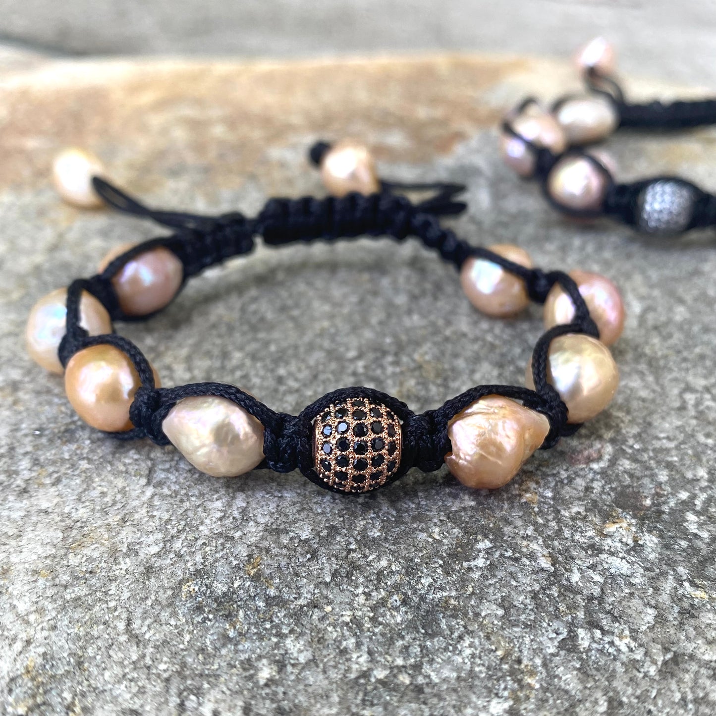Baroque pearl bracelet featuring pastel pearls and black macramé thread, crafted for a modern, feminine touch.