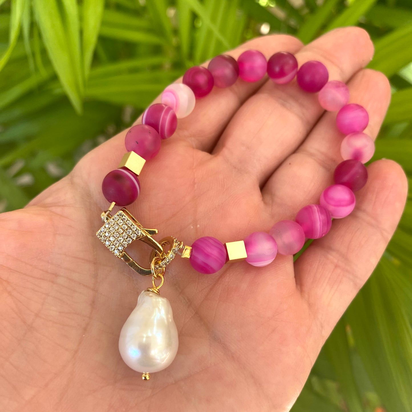 Sardonyx baroque pearl bracelet featuring hot pink sardonyx beads held in hand