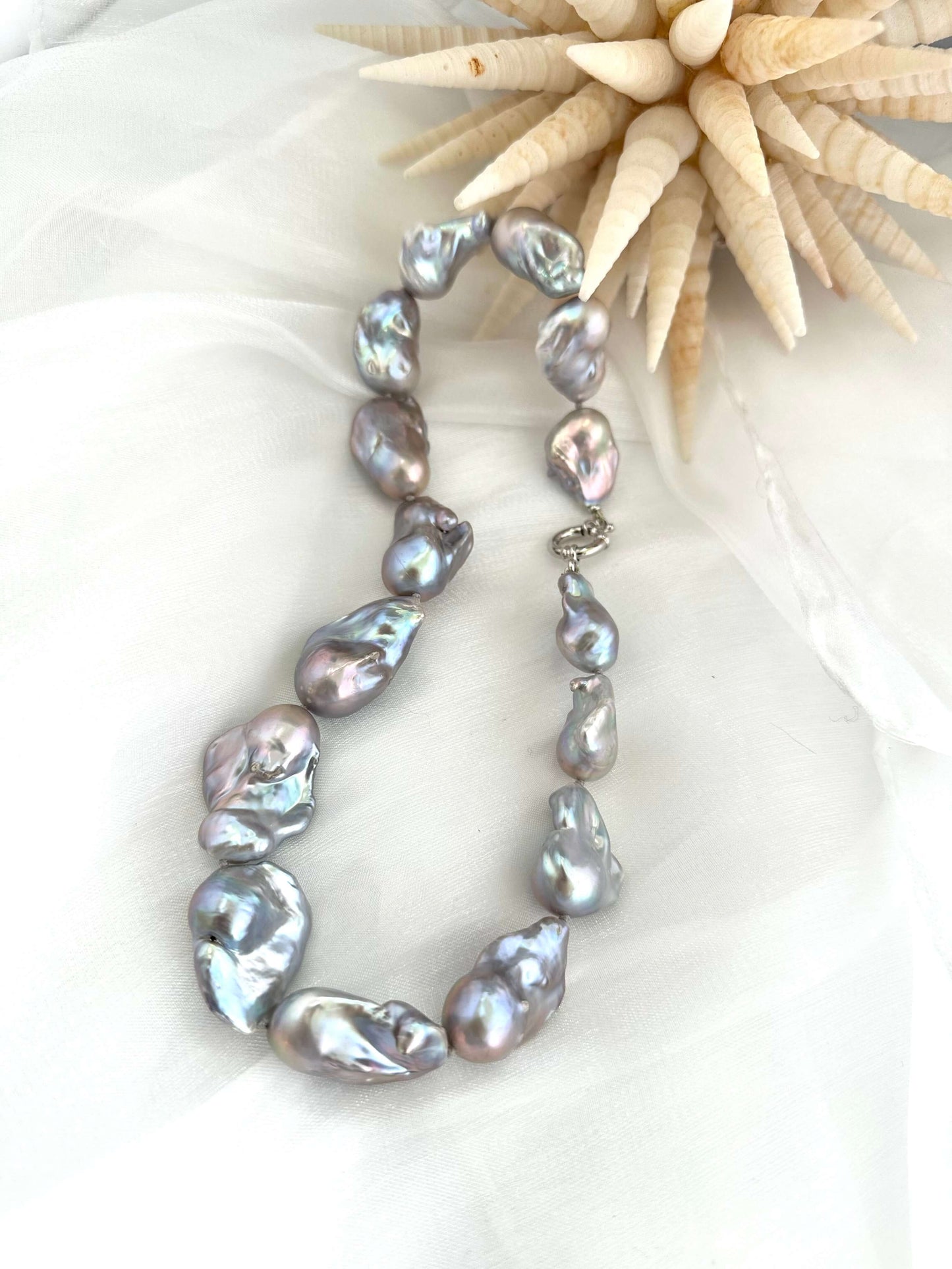 Baroque pearl necklace with silver details, featuring large silver-grey pearls with iridescent undertones.