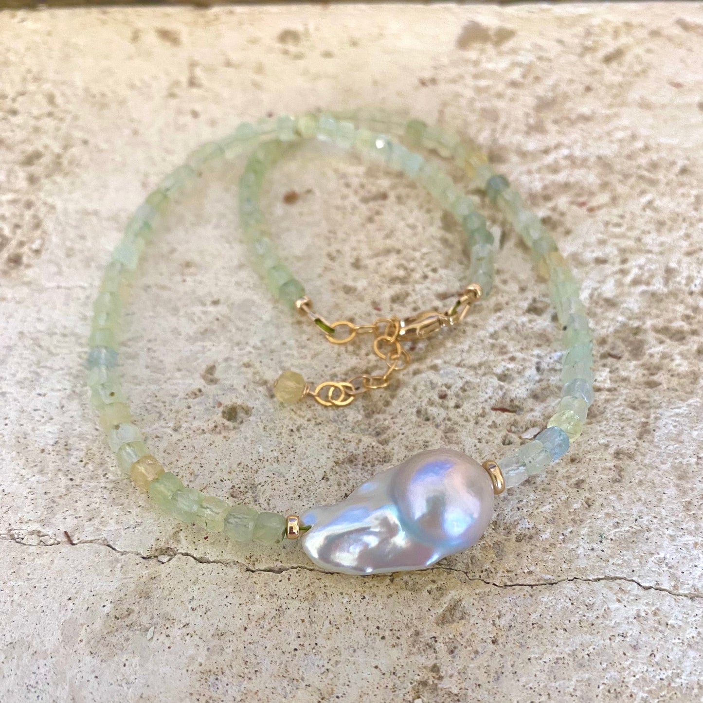 Prehnite necklace featuring light green prehnite and a baroque pearl centerpiece, showcasing elegant craftsmanship.