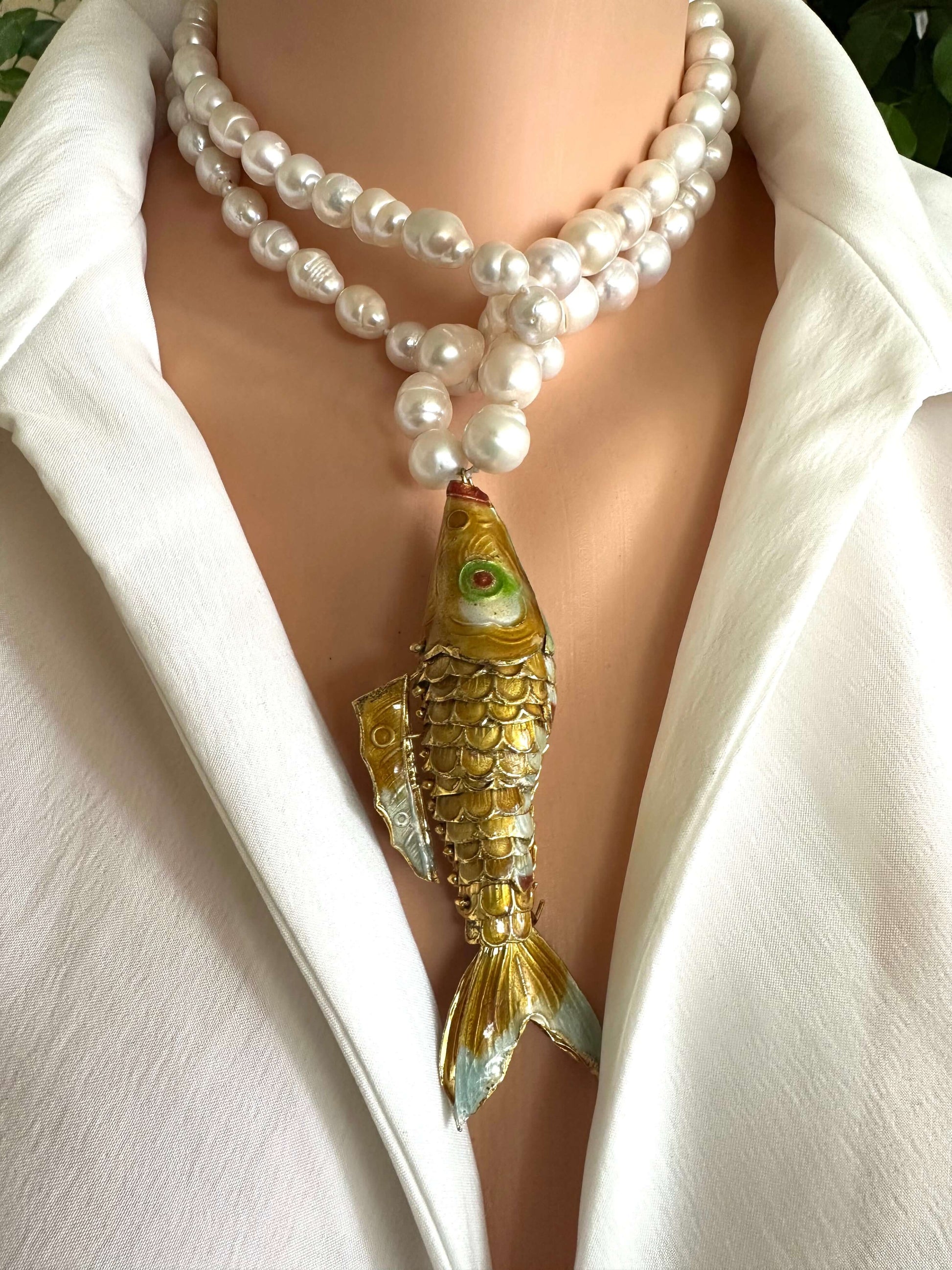 Baroque pearl necklace with fish pendant featuring hand knotted white pearls and a gold-tone fish centerpiece.