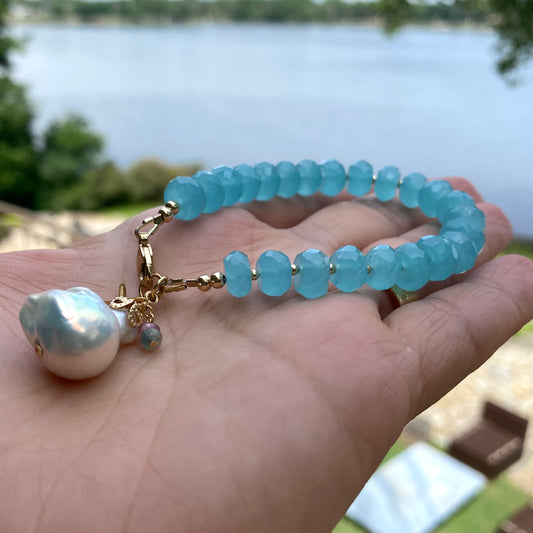 Chalcedony bracelet featuring aqua blue beads and a baroque pearl charm, perfect for ocean-inspired elegance.