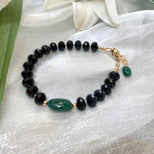 Load image into Gallery viewer, Spinel emerald bracelet featuring black spinel beads and a green emerald centerpiece on a silky background.
