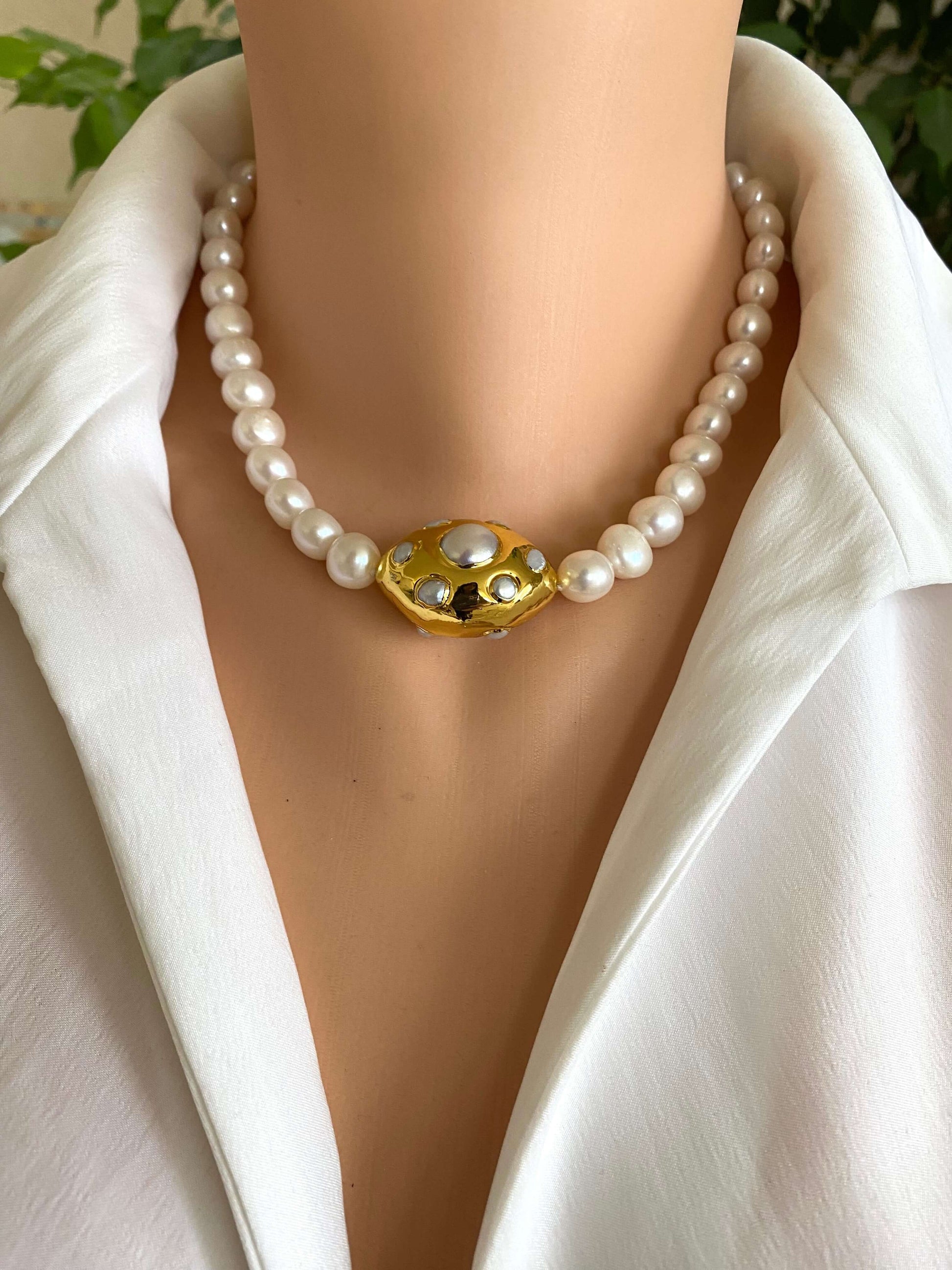 White potato pearl necklace with gold focal accent displayed on a mannequin.
