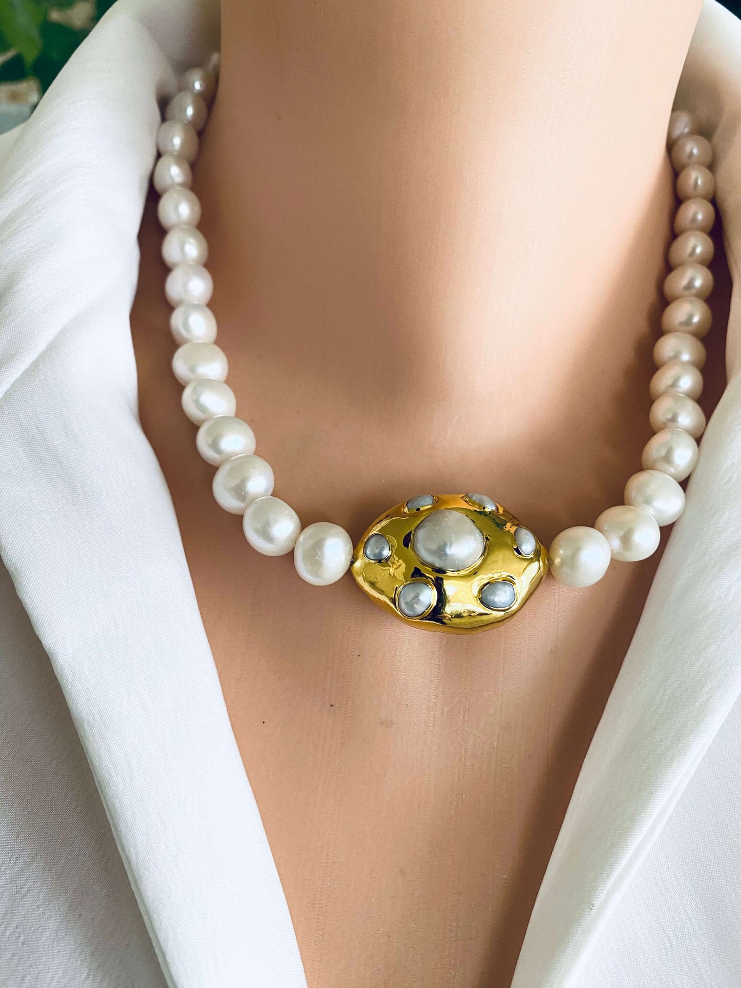 Close-up of a white potato pearl necklace with a gold focal accent, showcasing hand knotted freshwater pearls.