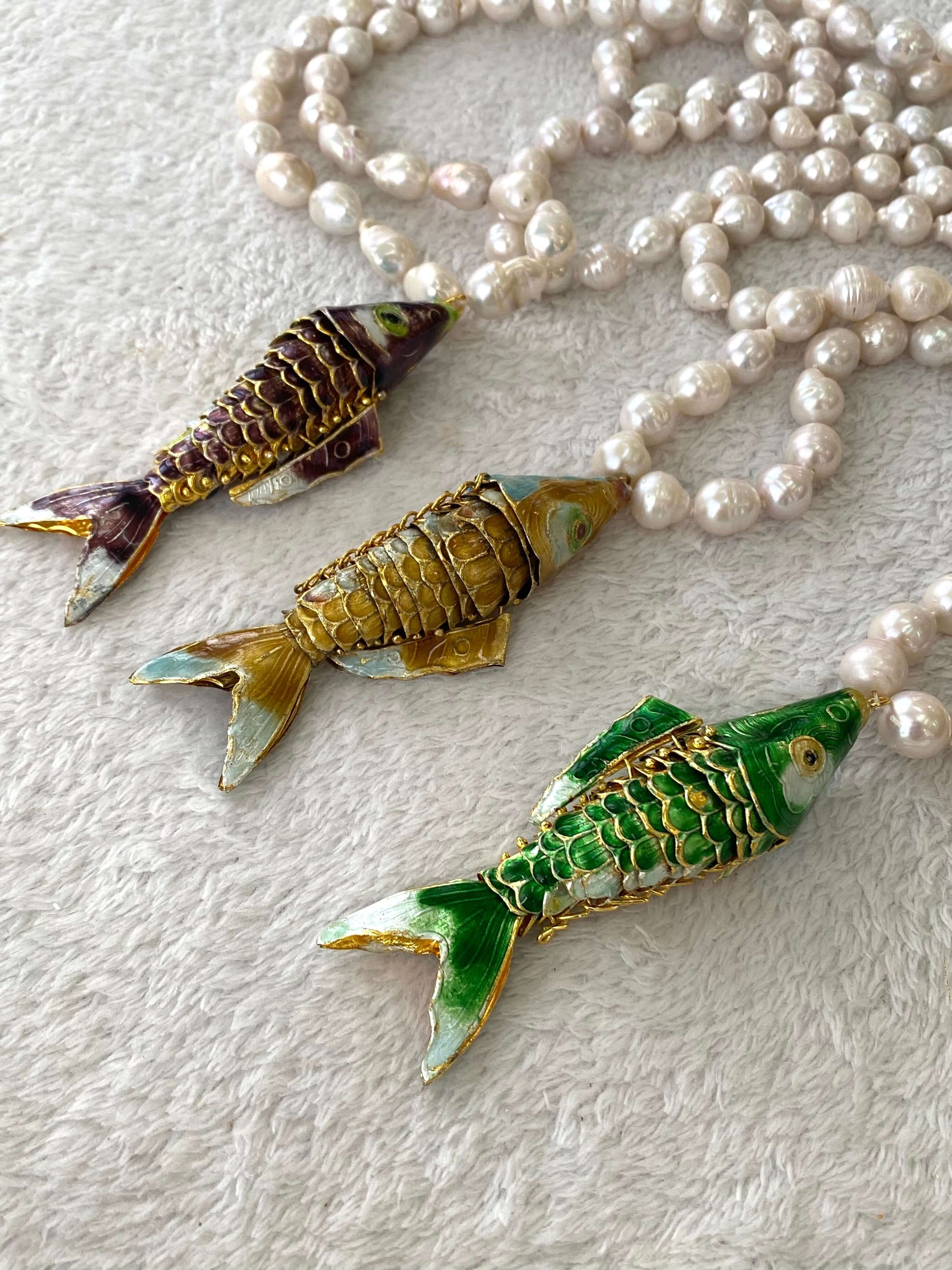 Baroque pearl necklace with fish pendant featuring three colorful fish pendants and lustrous white pearls.