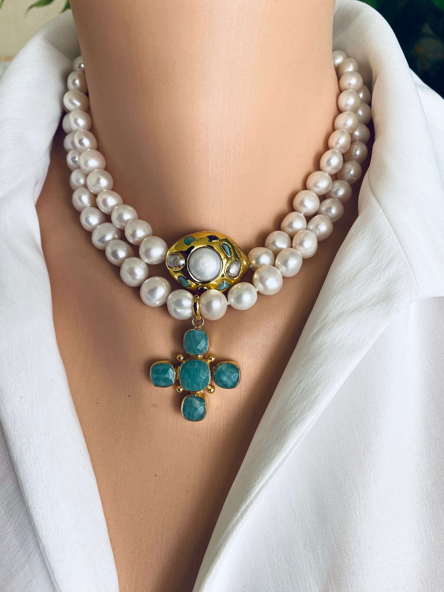 White pearl necklace with gold accent featuring a decorative centerpiece and double strand of freshwater pearls.