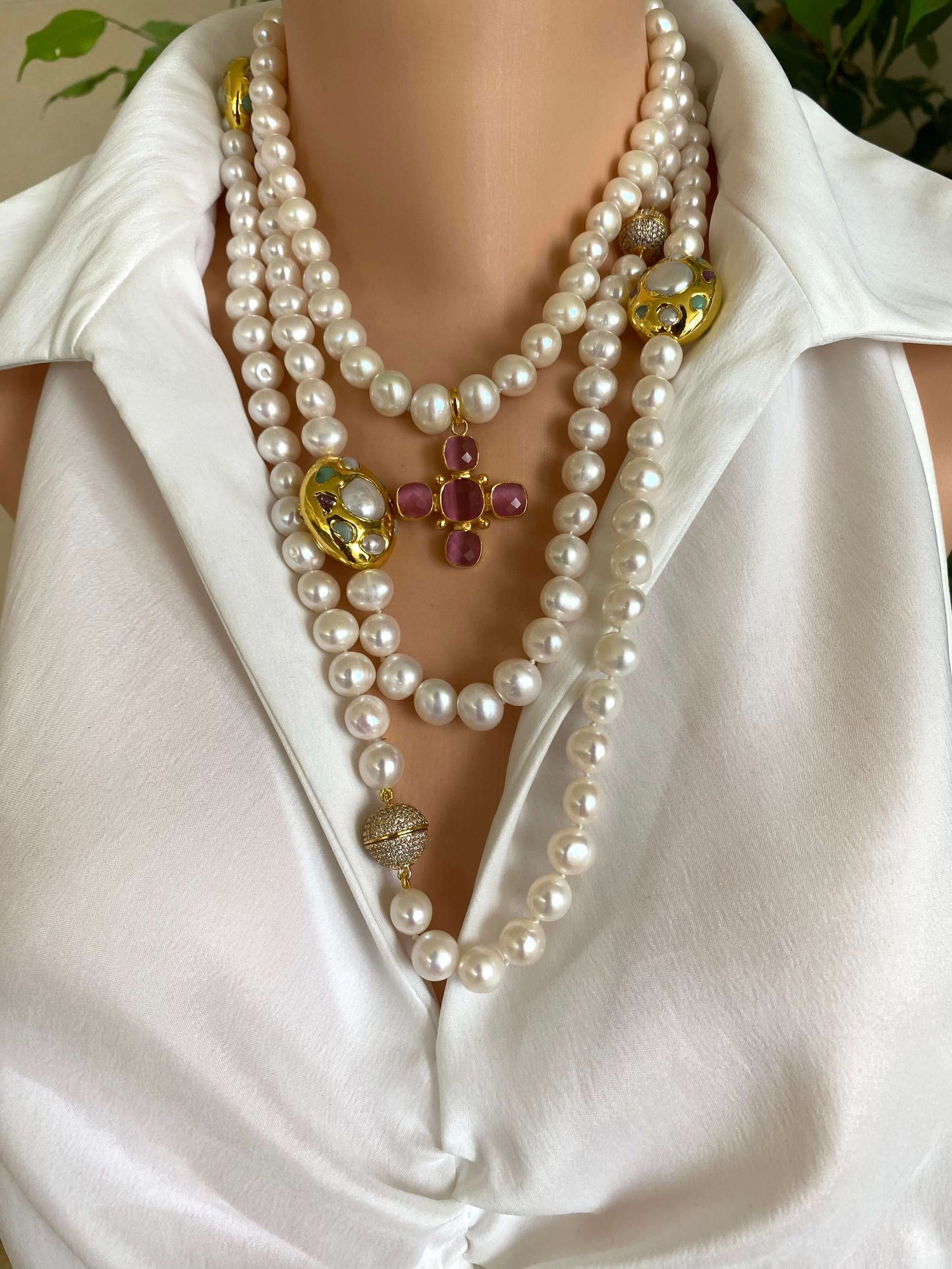 White pearl necklace with gold accent featuring layered designs and colorful focal pieces.