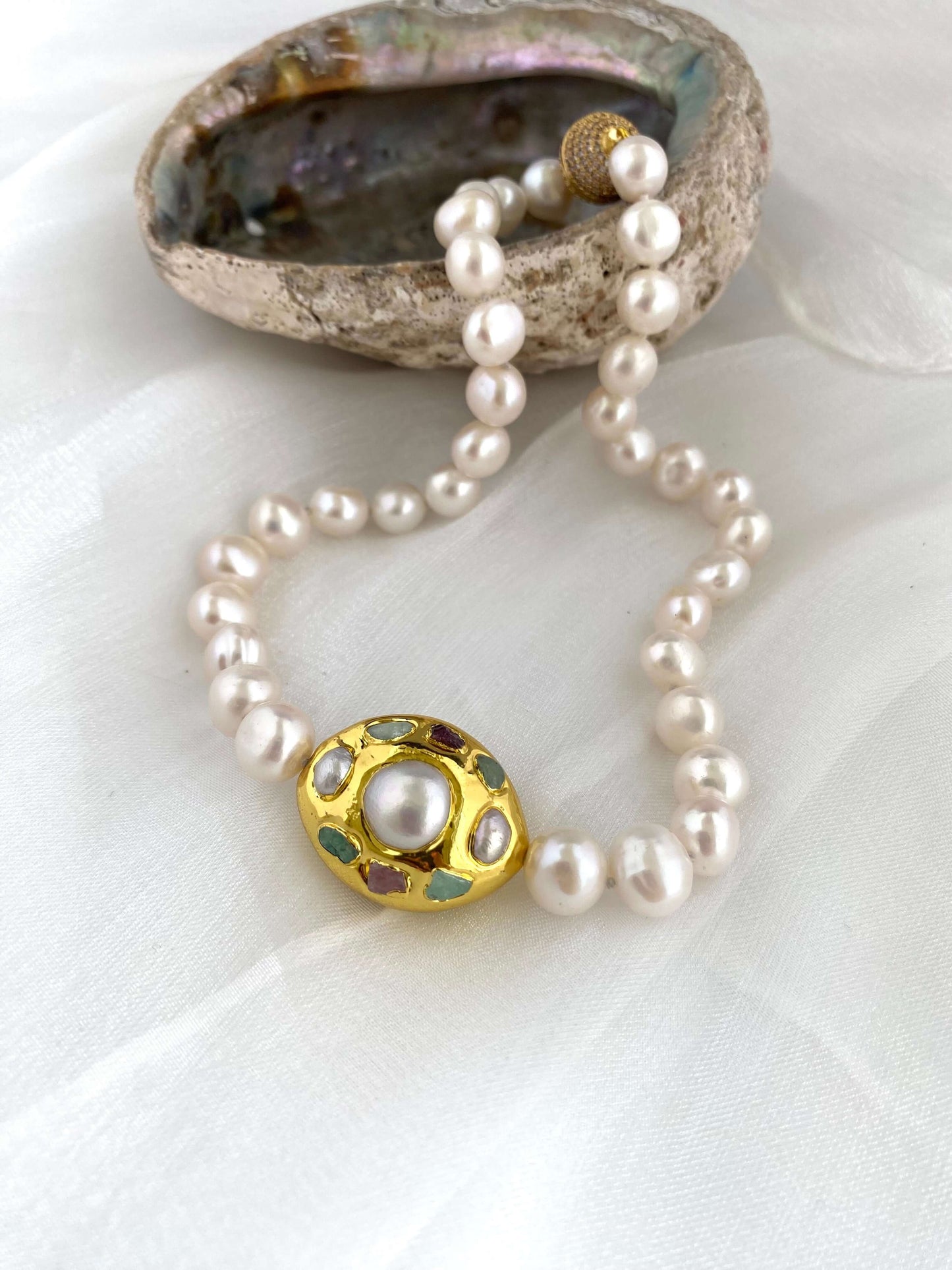 White pearl necklace with gold accent featuring hand-knotted freshwater pearls and a decorative gold-plated focal point.