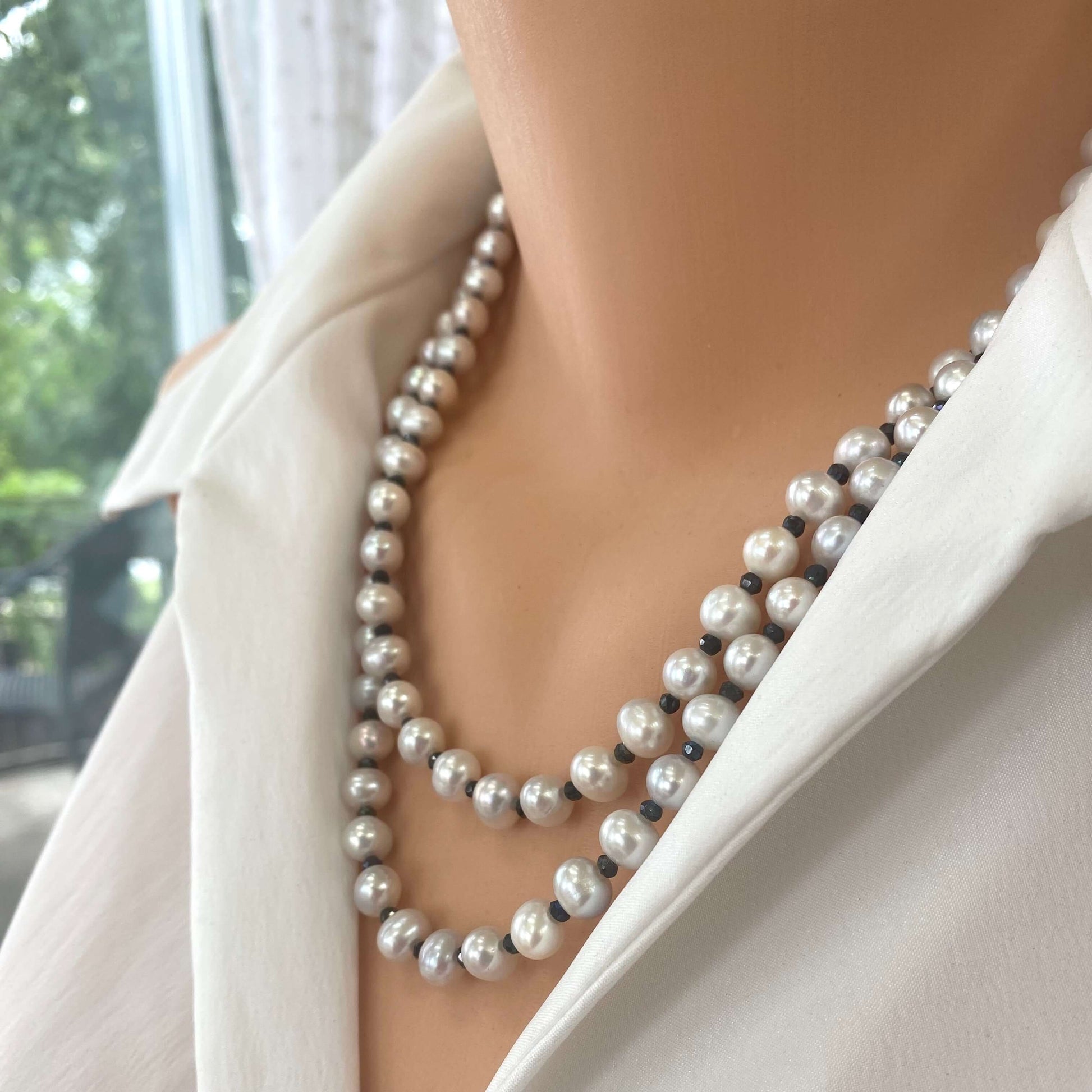 Light grey freshwater pearl necklace shown on a mannequin, featuring long silver and spinel design.