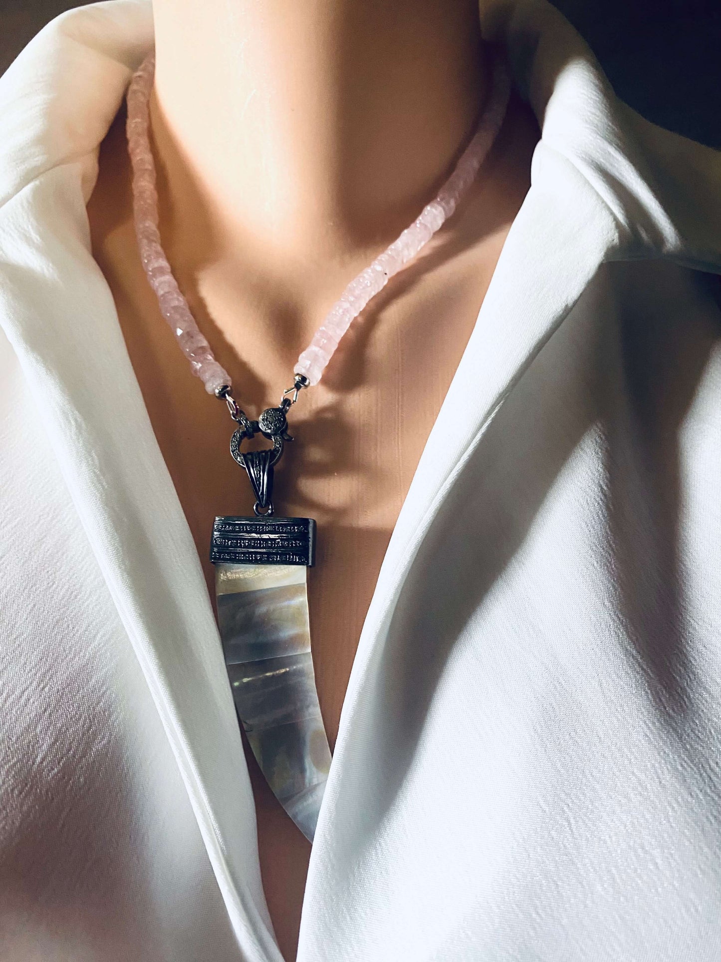 Rose quartz beaded necklace with oxidized silver pavé clasp showcased elegantly on a mannequin, highlighting its beauty.