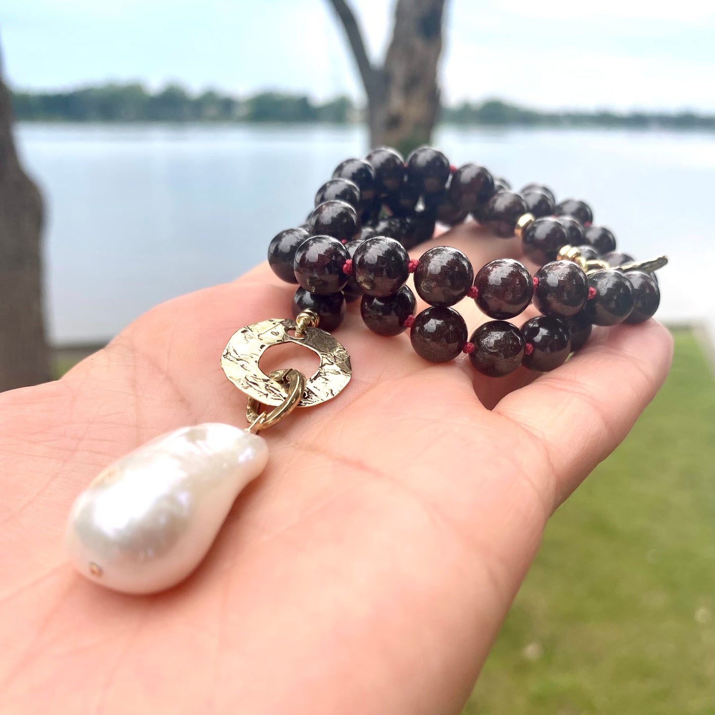Garnet pearl necklace featuring garnet beads baroque pearl pendant and gold bronze details