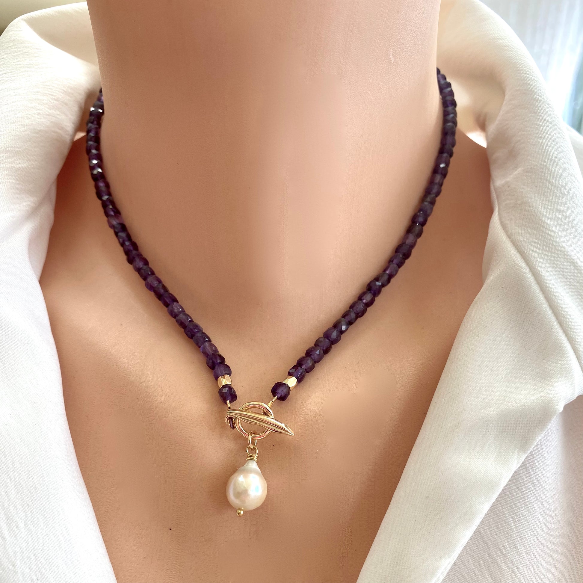 Amethyst toggle necklace with baroque pearl charm showcasing faceted amethyst beads and elegant gold toggle clasp.