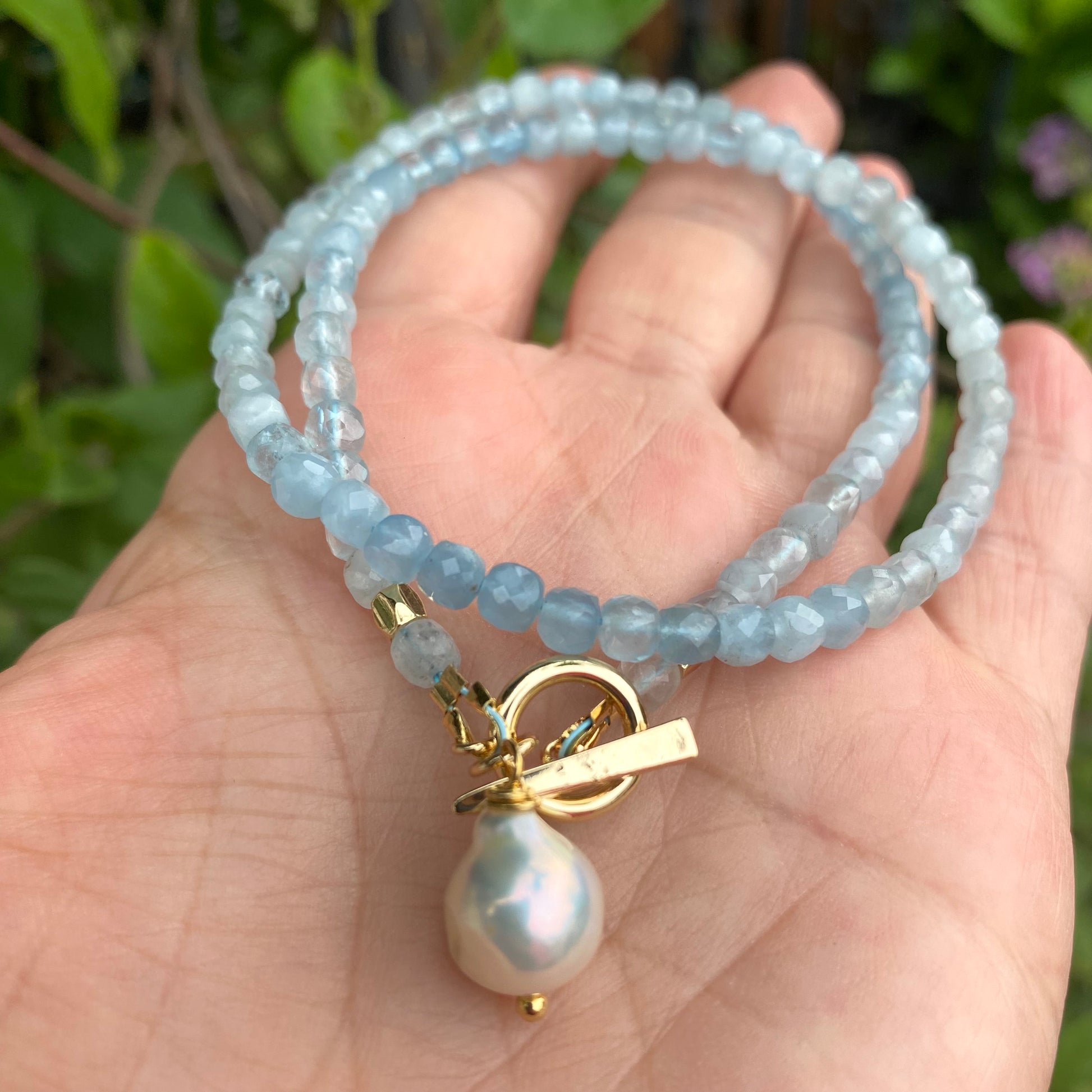 Aquamarine toggle necklace with baroque pearl pendant showcasing delicate craftsmanship and soothing blue tones.