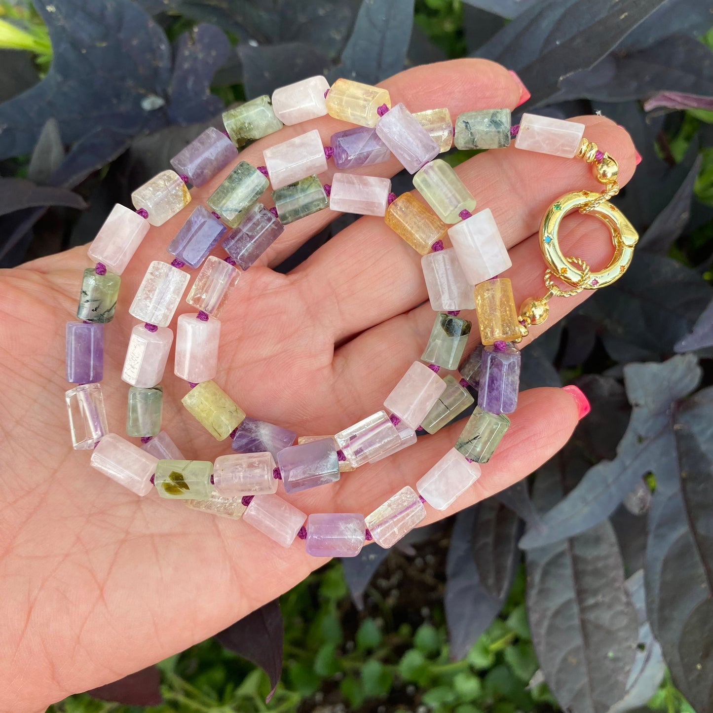 Mixed gemstone necklace with rose quartz, amethyst, citrine, and prehnite beads held in hand, handmade in Canada