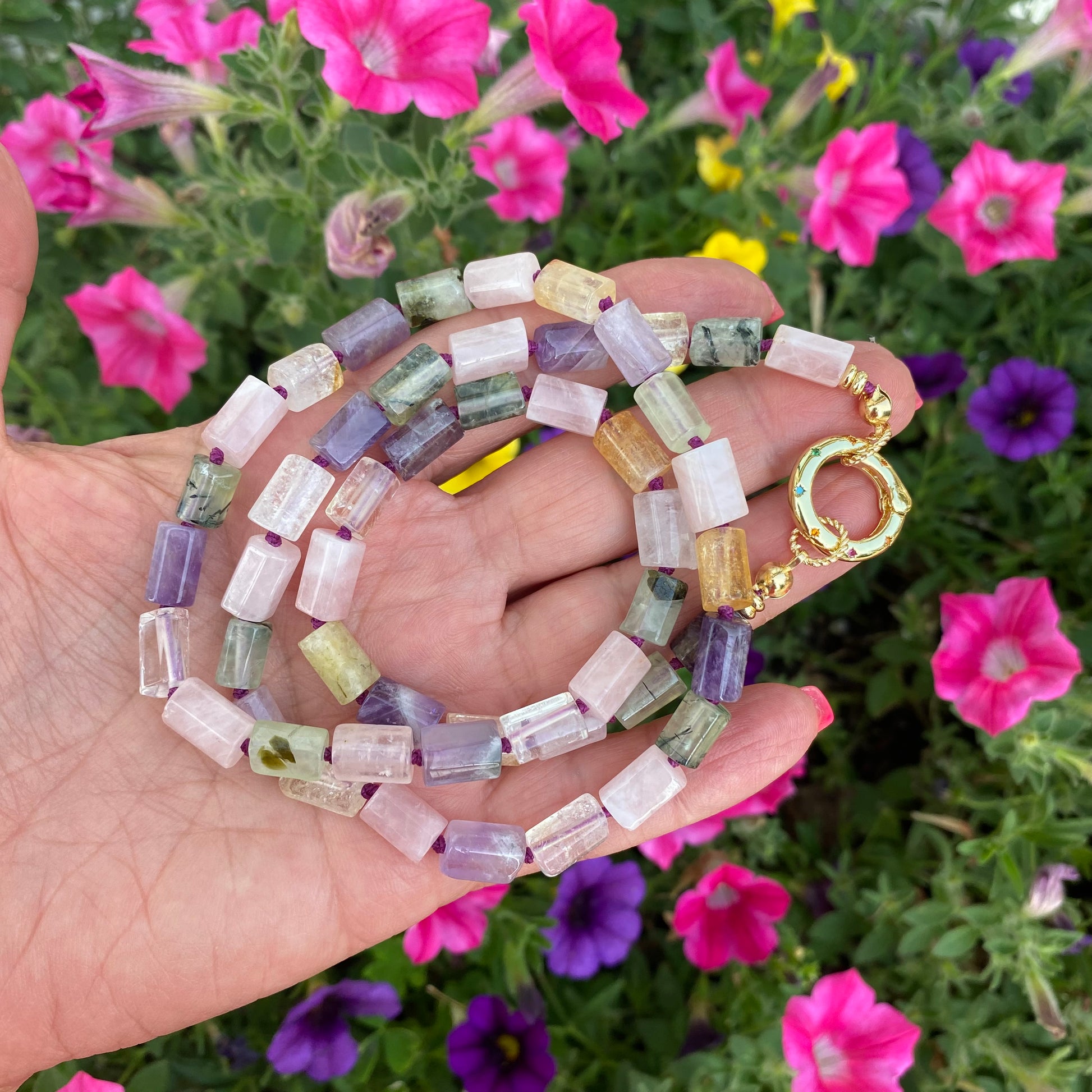 Mixed gemstone necklace with rose quartz and amethyst tube beads held in hand against floral background, handmade in Canada