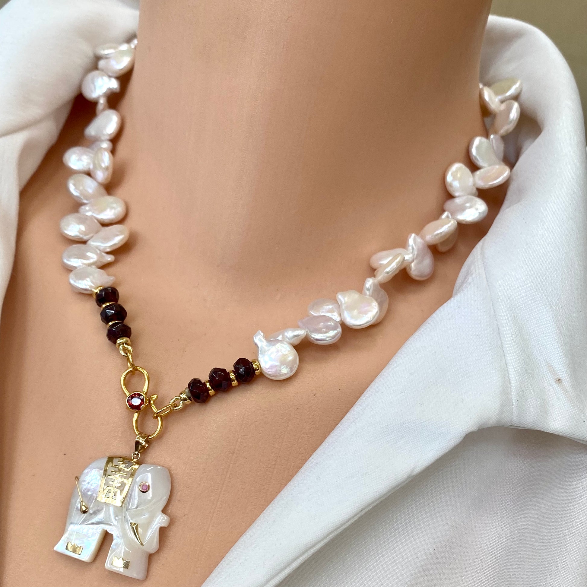 Keshi pearl necklace featuring garnet beads and an elephant pendant, highlighting the organic charm of genuine freshwater pearls.