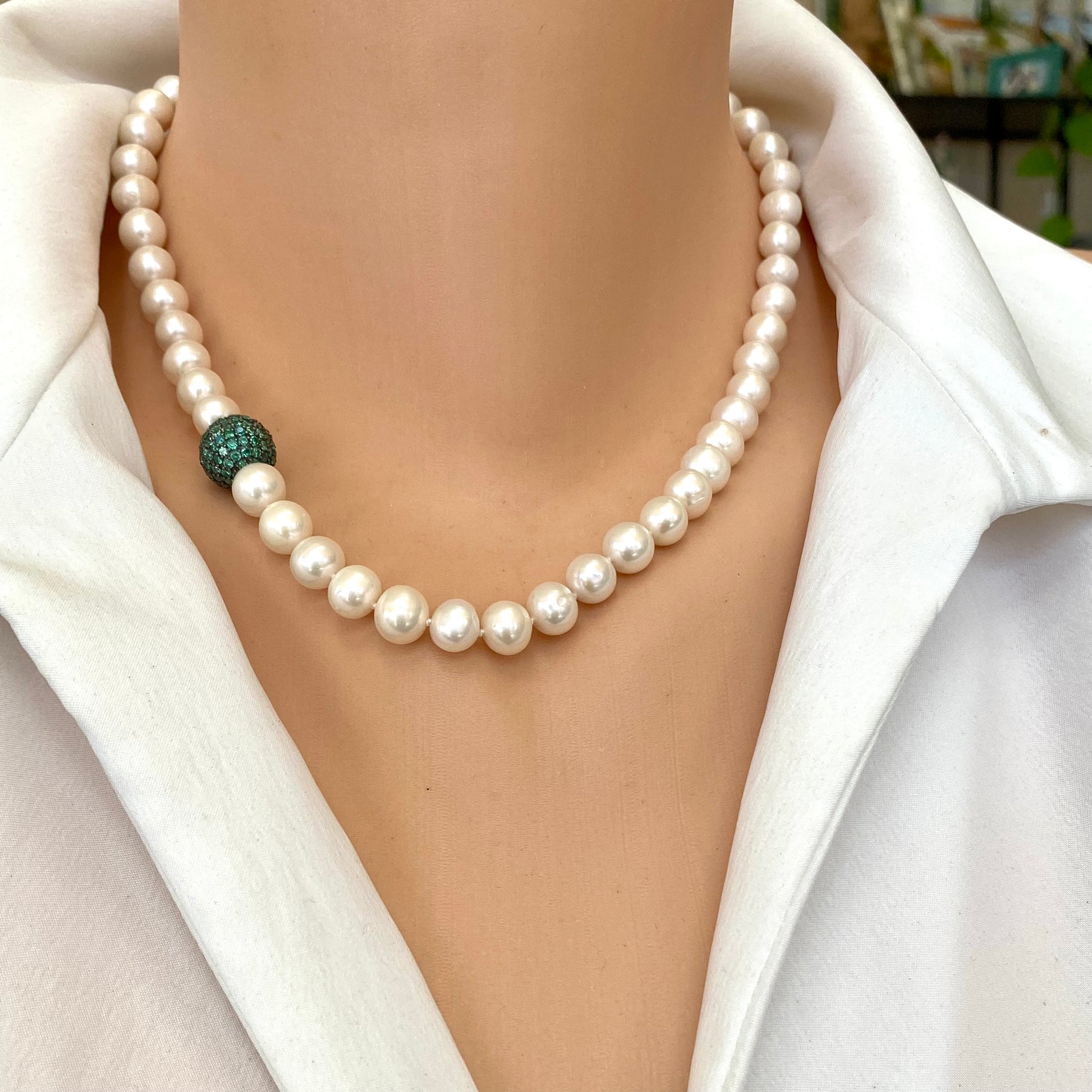 Pearl necklace with green CZ bead worn on a mannequin, showcasing handcrafted elegance and modern design.