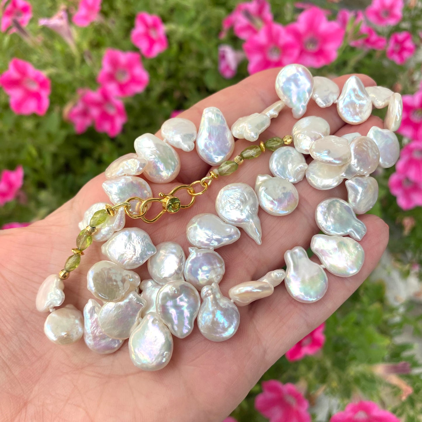 Keshi pearl necklace featuring lustrous freshwater pearls, accented with garnet, citrine, or peridot against a floral background.