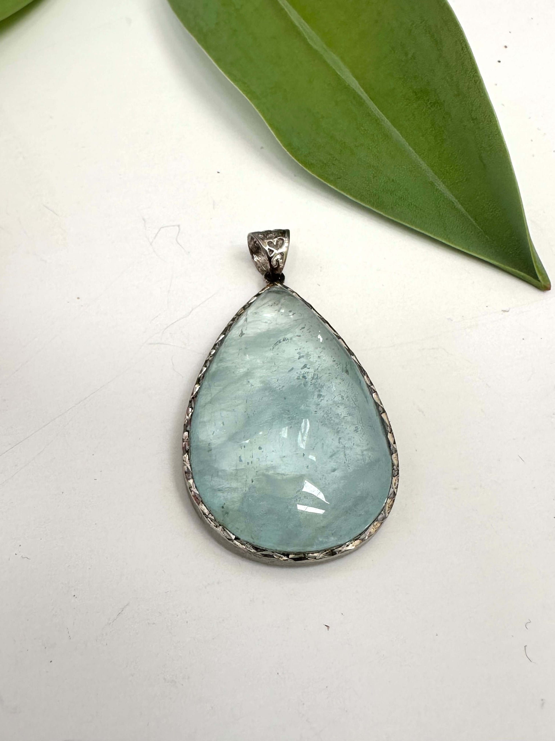 Aquamarine teardrop pendant in oxidized sterling silver featuring pear-shaped aquamarine stone with natural inclusions.