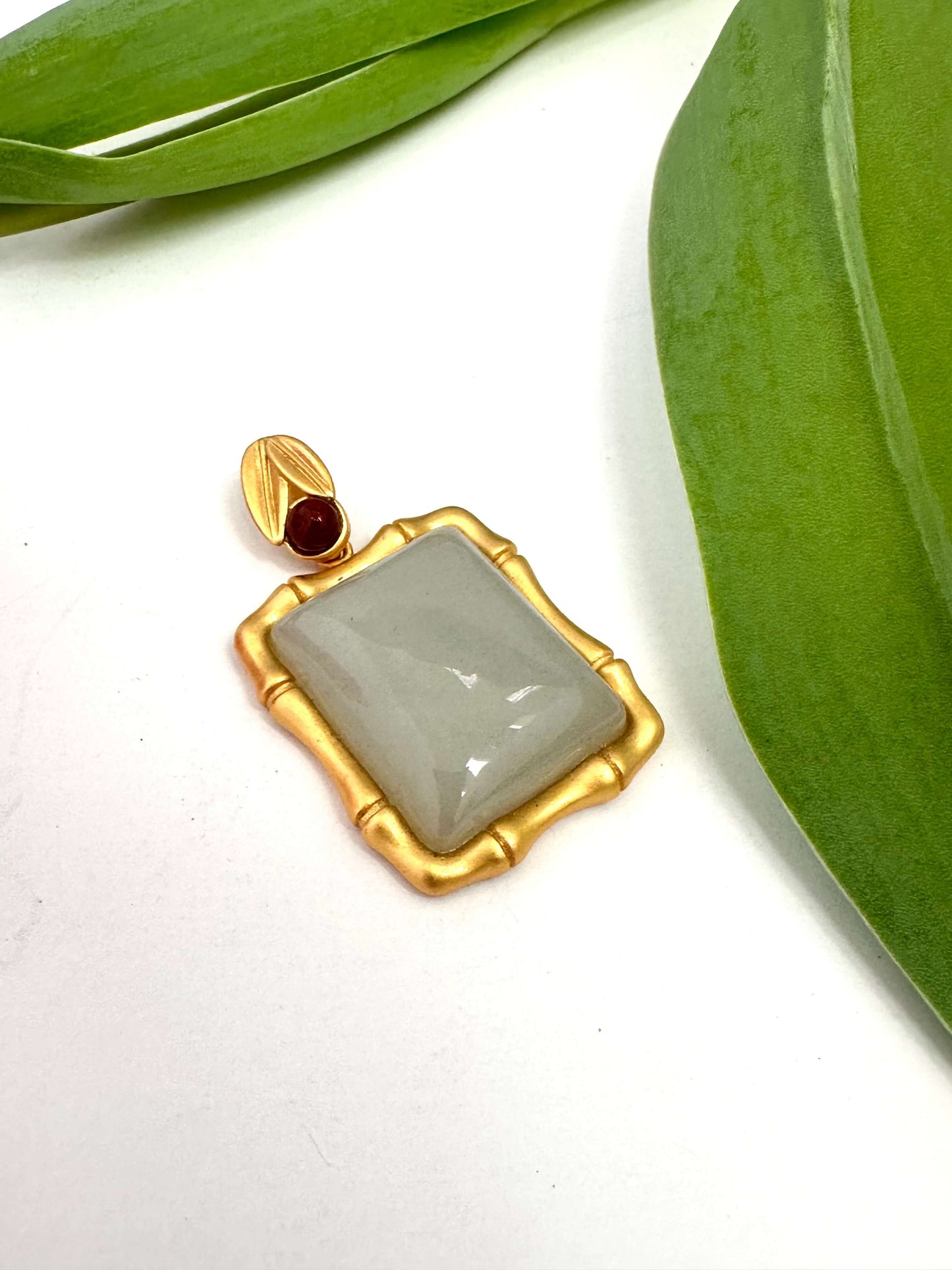Bamboo style jade pendant with red agate in gold vermeil setting, showcasing natural jade and unique design.
