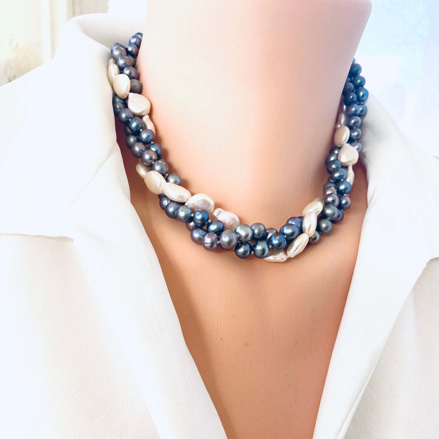 Front view of Black and White Pearl Necklace on mannequin highlighting black pearls and white coin pearl centerpiece.