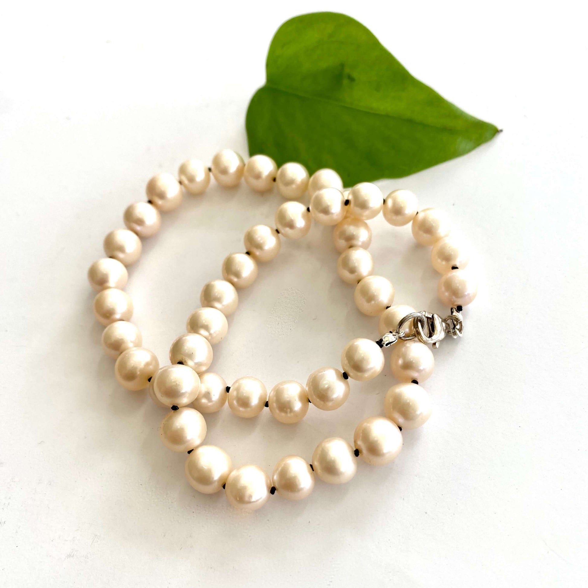 Off white pearl choker necklace close-up on white fabric