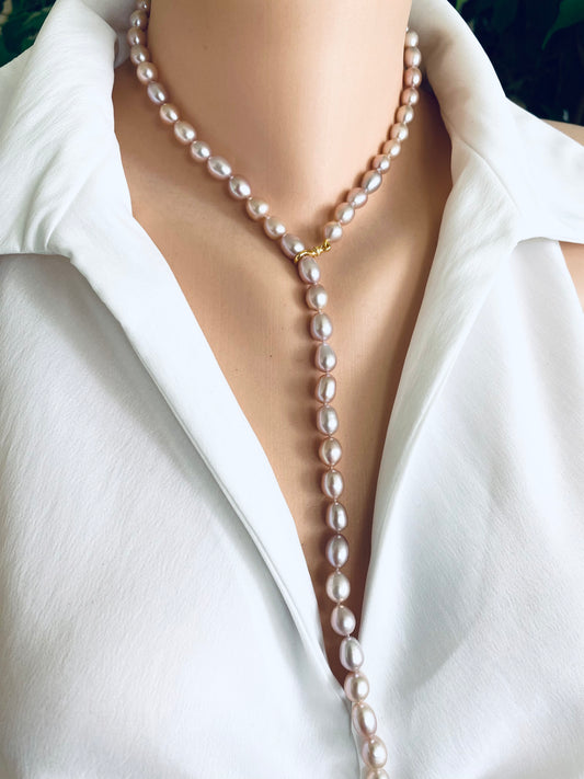 Pearl necklace worn by a person in a white shirt