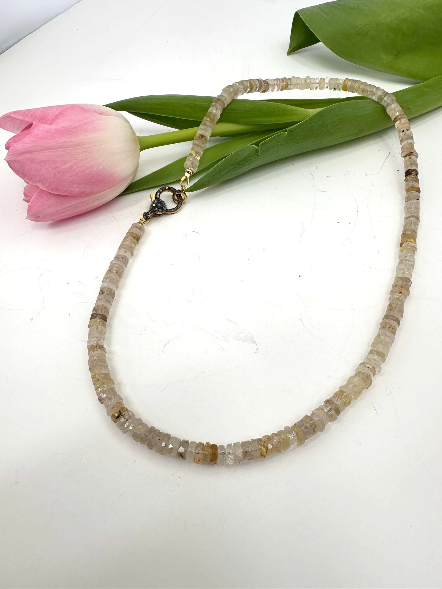 Rutilated quartz gemstone necklace with oxidized vermeil pavé clasp showcasing faceted beads and natural golden rutile inclusions.