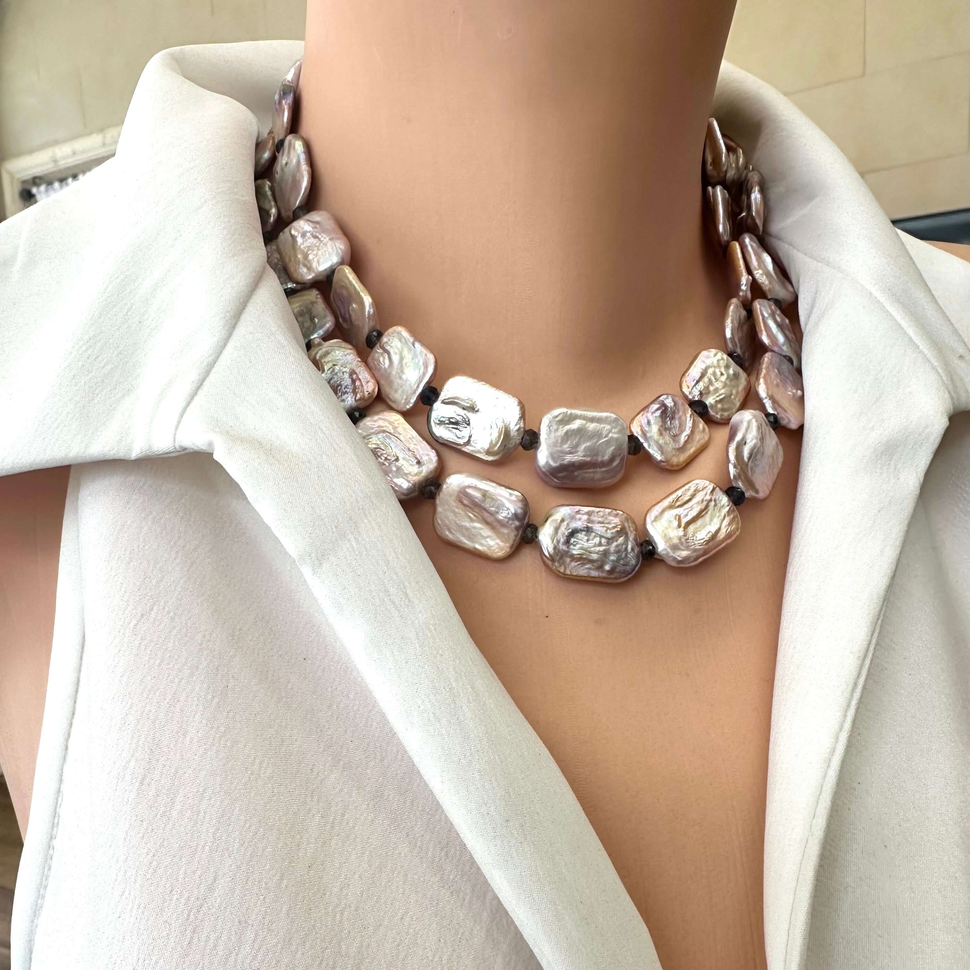 Detailed side close-up of two-strand Statement Pearl Necklace featuring pink pearls and iolite beads on mannequin neck.