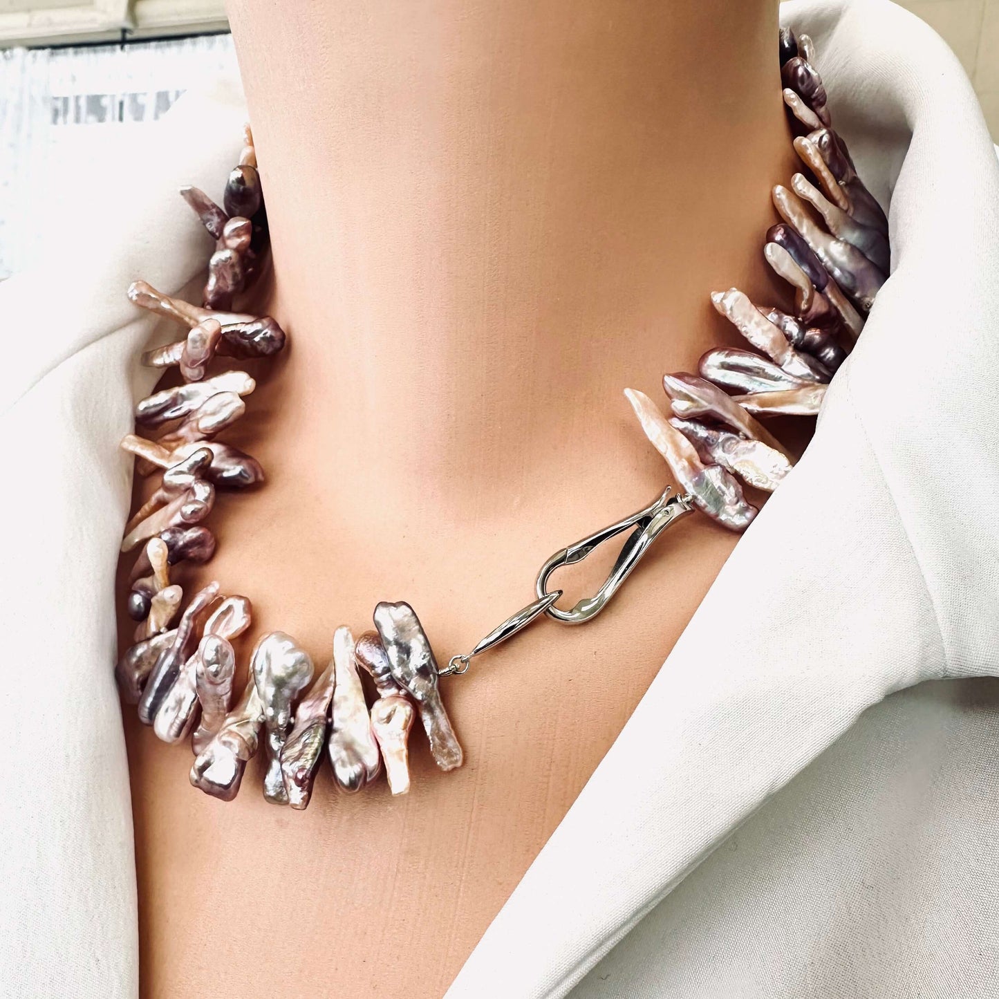 Biwa Pearl Necklace with purplish long stick pearls shown in side close-up on mannequin.