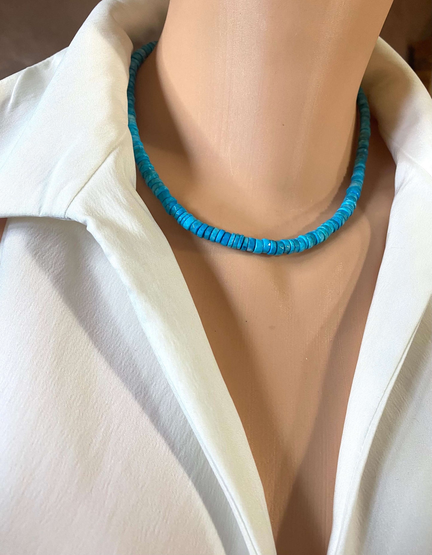 Turquoise howlite beaded necklace displayed on a mannequin wearing a white shirt, showcasing its vibrant color and texture.