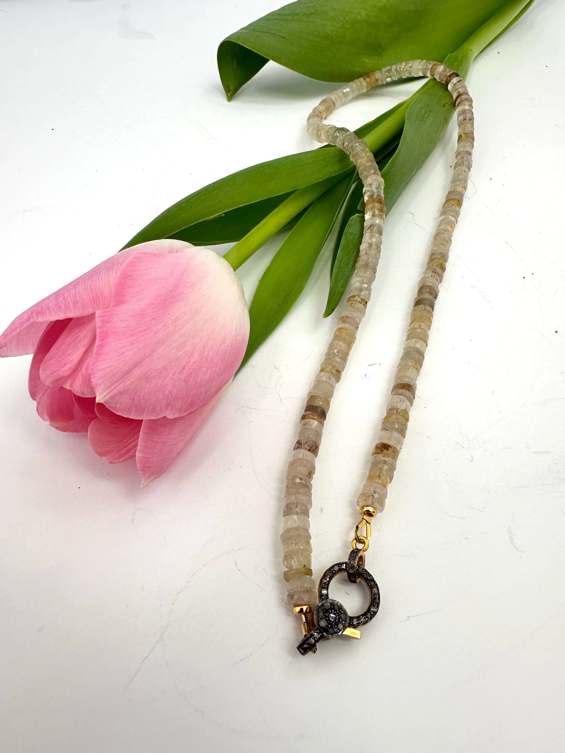 Rutilated quartz gemstone necklace with oxidized vermeil pavé clasp and fresh pink tulip.