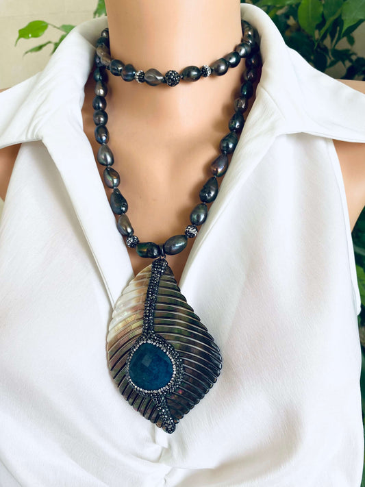 Long peacock black pearl necklace with abalone agate pendant displayed on a mannequin.