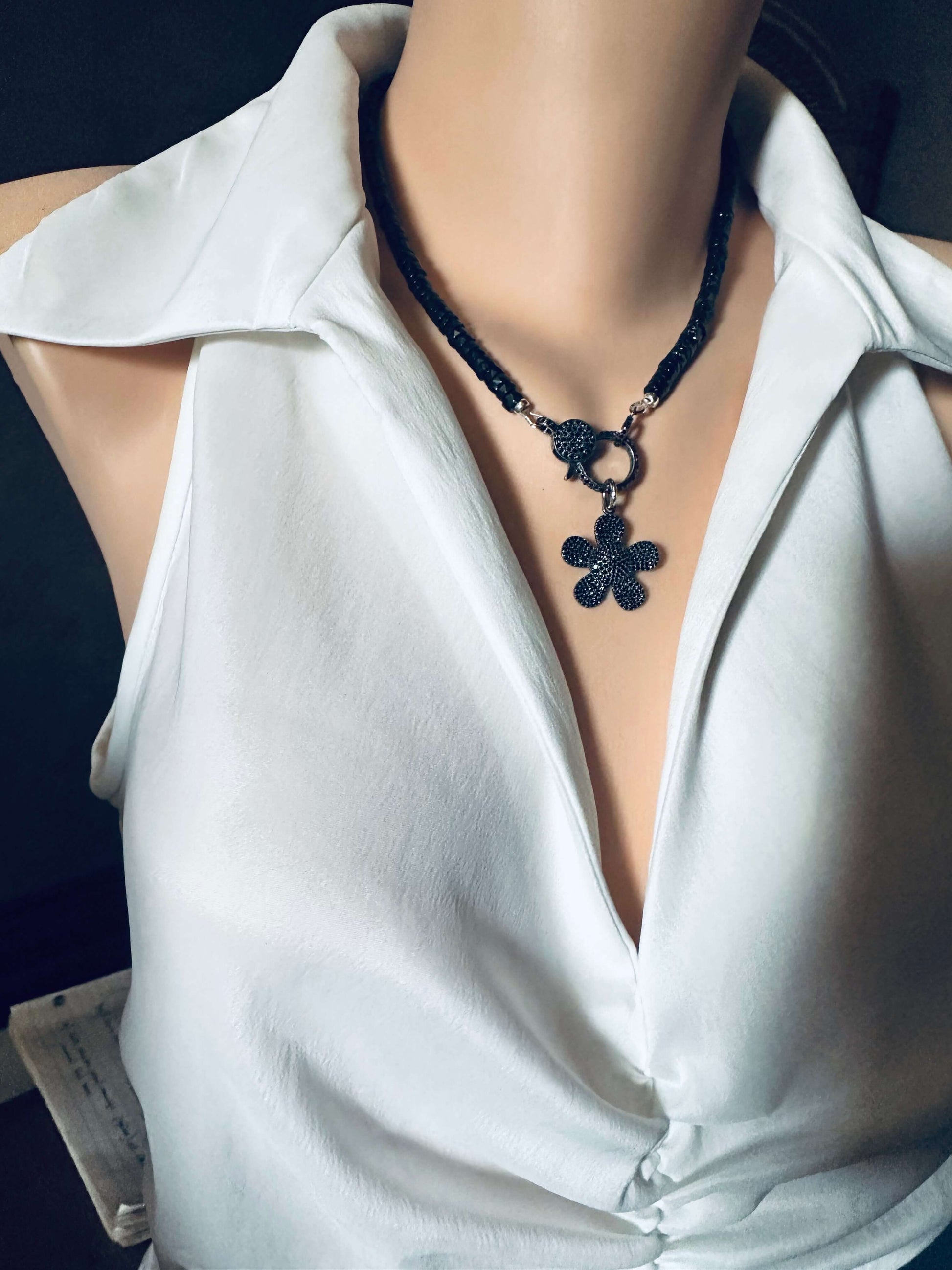 Black Spinel Daisy Pendant Necklace in Oxidized Silver – 18” worn on a mannequin with a white blouse.