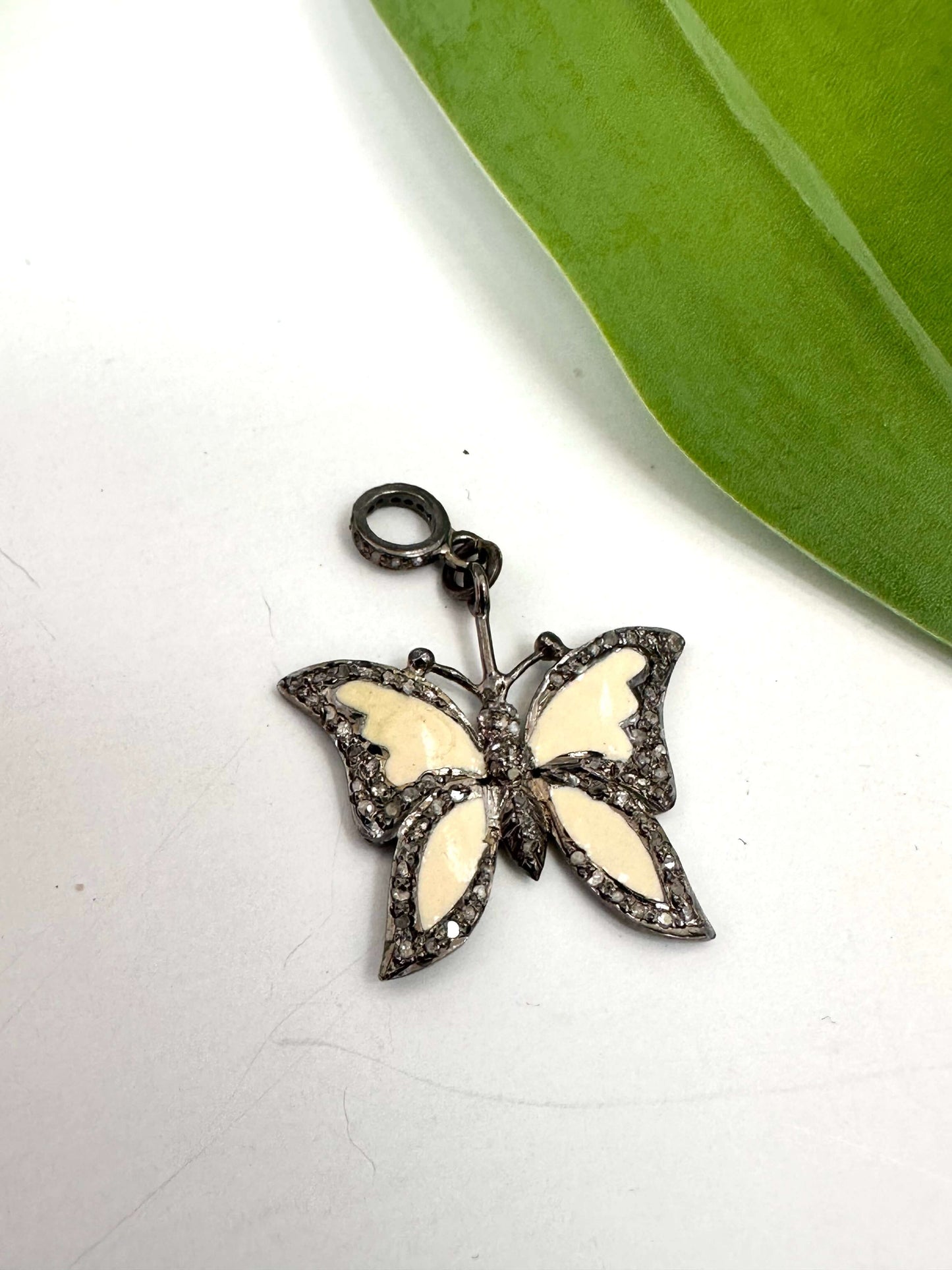 Enamel butterfly pendant with diamond pavé in sterling silver showcasing off-white enamel wings and sparkling accents.