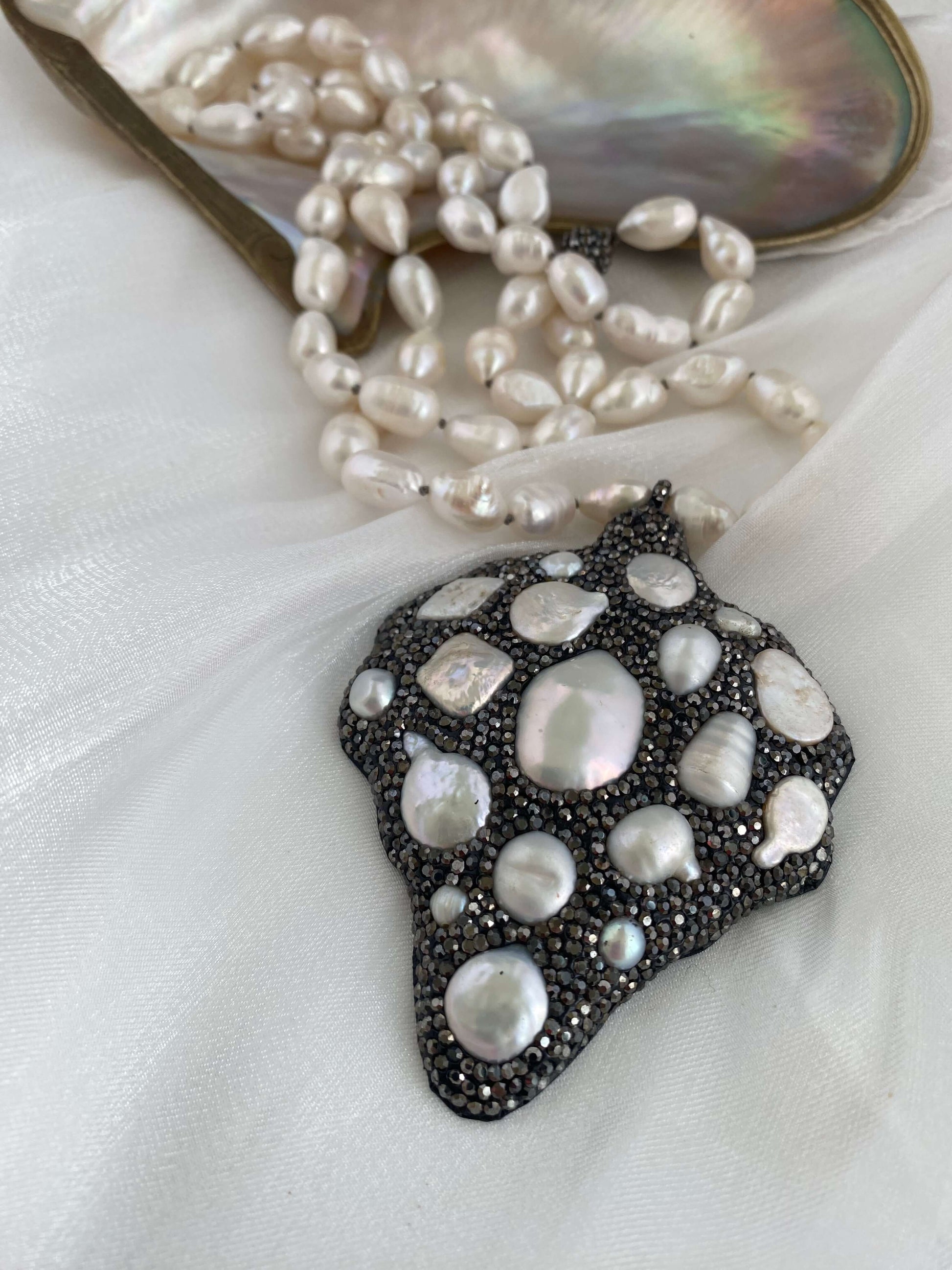 Long white pearl nugget necklace with Pavé pendant on a soft background, highlighting the luminous freshwater pearls.