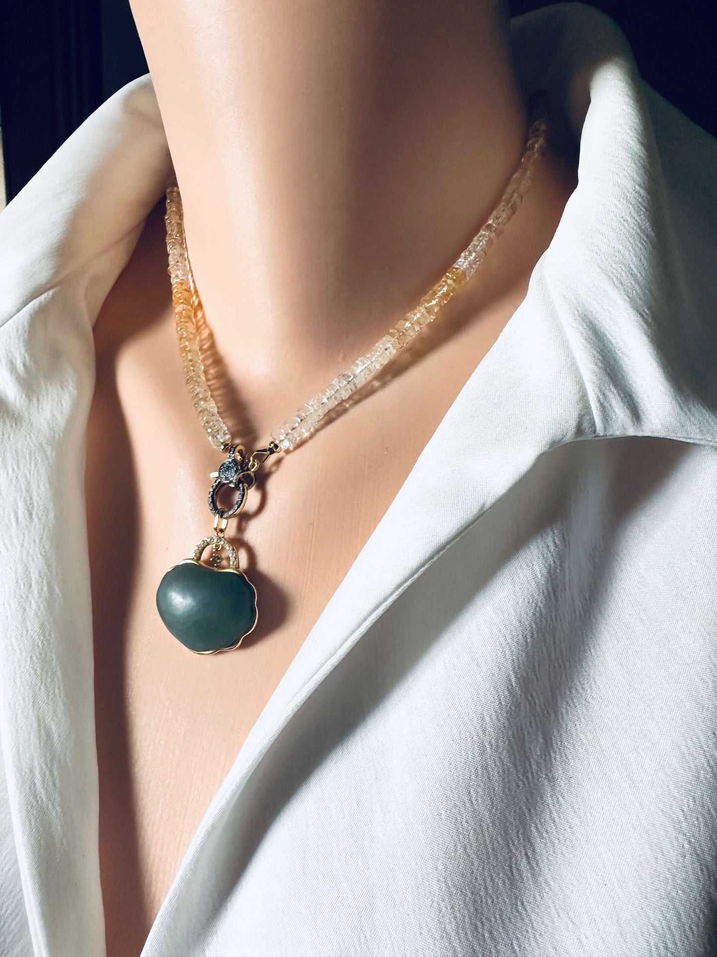 Shaded citrine gemstone necklace with a diamond pavé gold vermeil clasp worn on a mannequin.