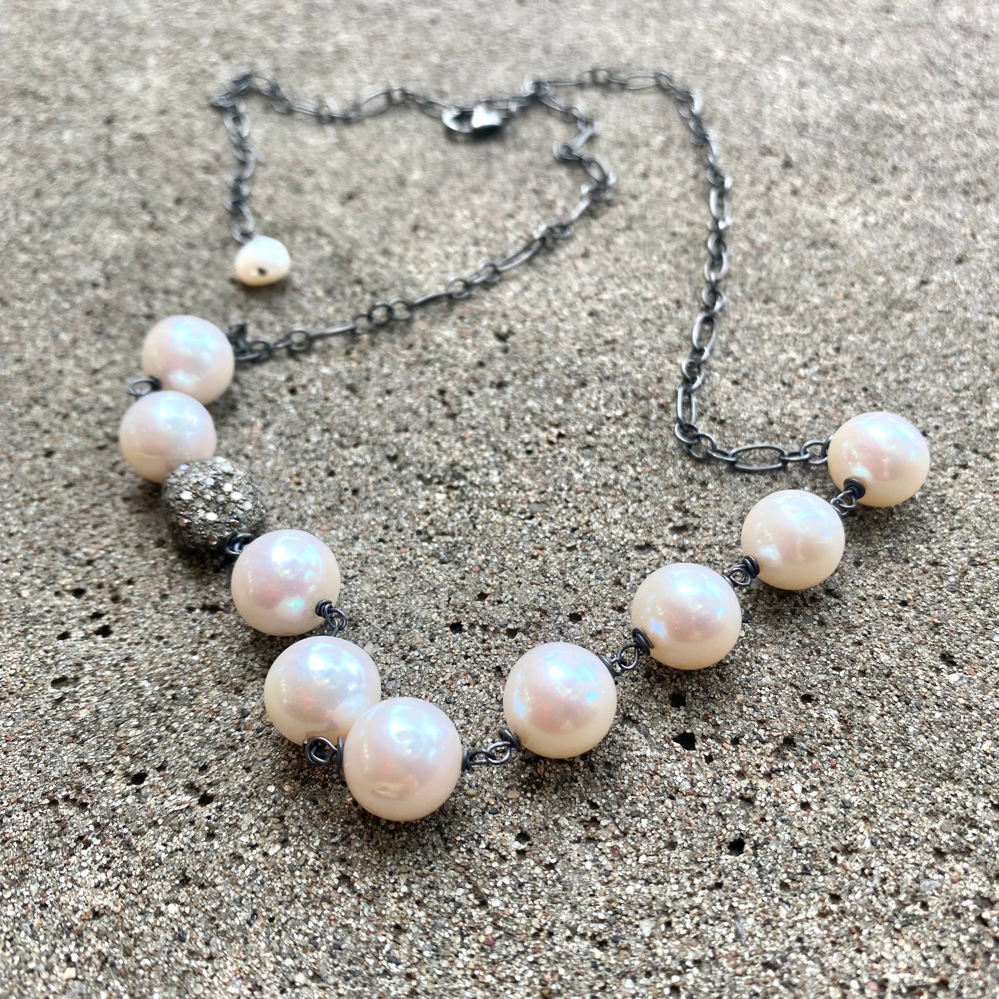 Pearl necklace wire wrapped in silver, featuring high-lustre freshwater pearls and a diamond pavé bead, handmade in Canada.