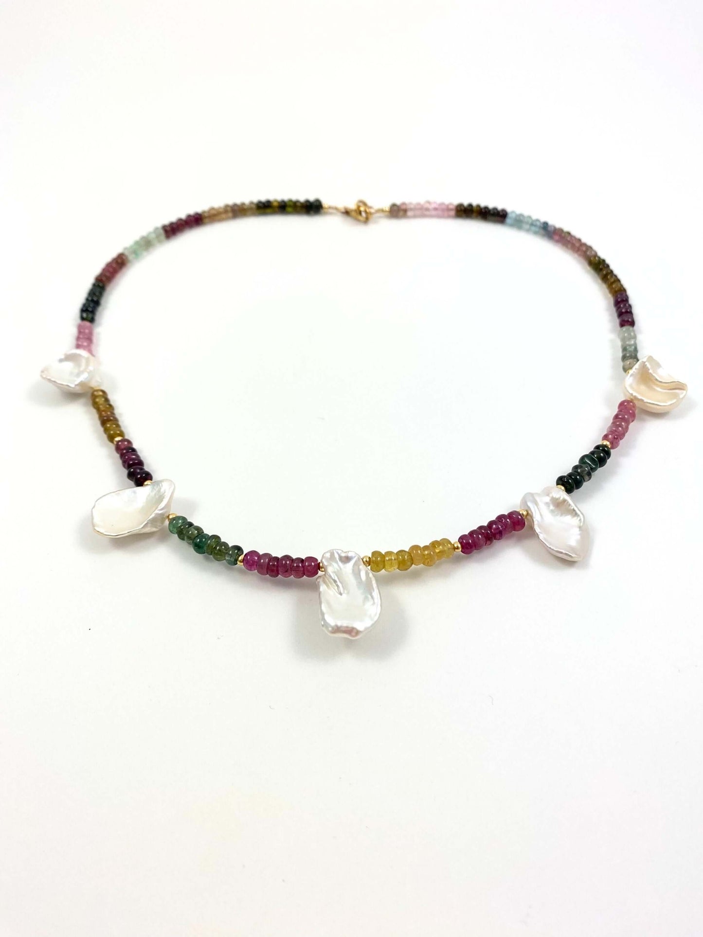 A beaded necklace featuring multicolored seed beads, irregular white mother-of-pearl shell charms, displayed on a clean white background.