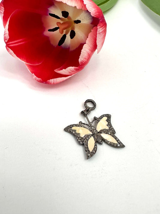 Enamel butterfly pendant with diamond pavé in sterling silver, featuring soft off-white enamel wings and diamond accents.
