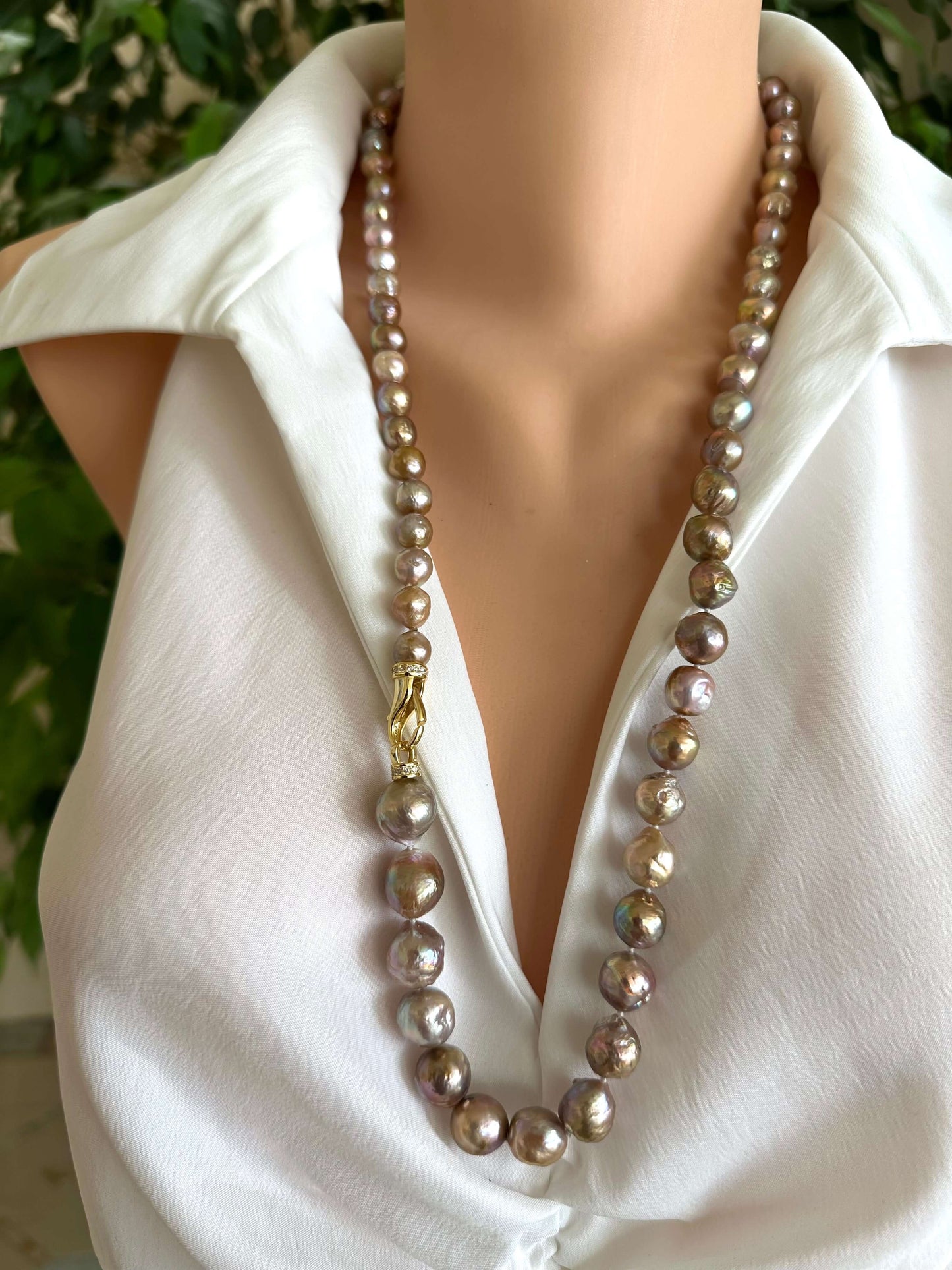 Long pink Edison baroque pearl necklace worn as single strand on white blouse